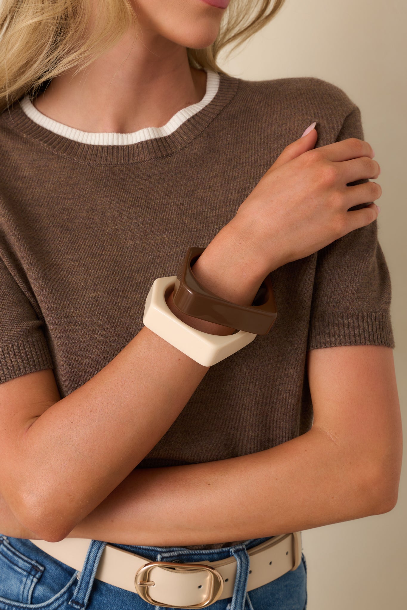 Cropped view of the cream and brown bangles stacked together, highlighting the bold square-edge silhouette.
