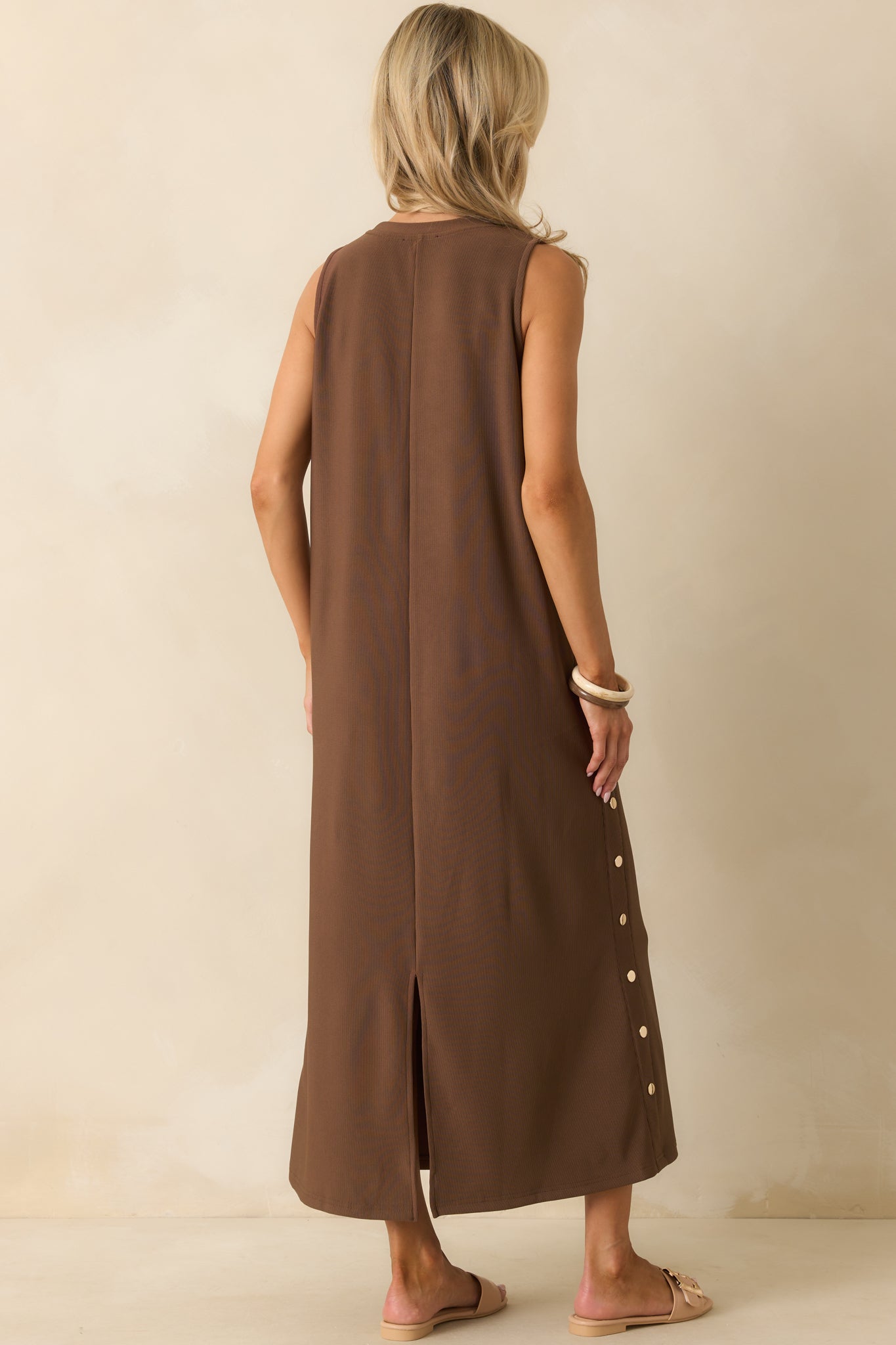 A view from behind of the maxi dress showing the center back seam and vent slit.