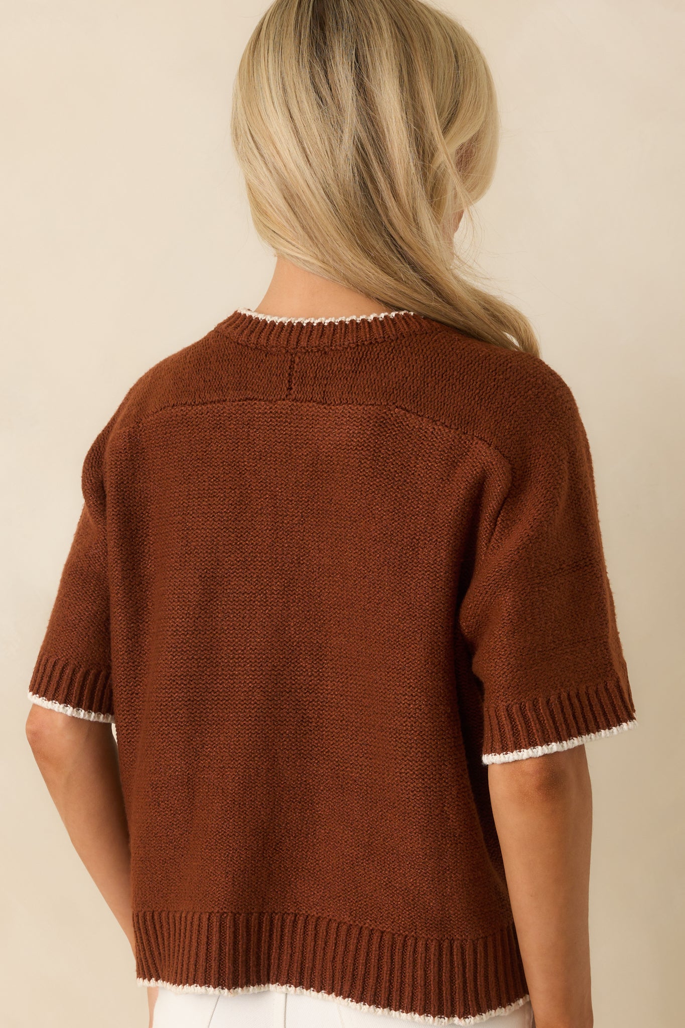 Rear view of the oversized brown sweater with ribbed hem and knit fabric design.