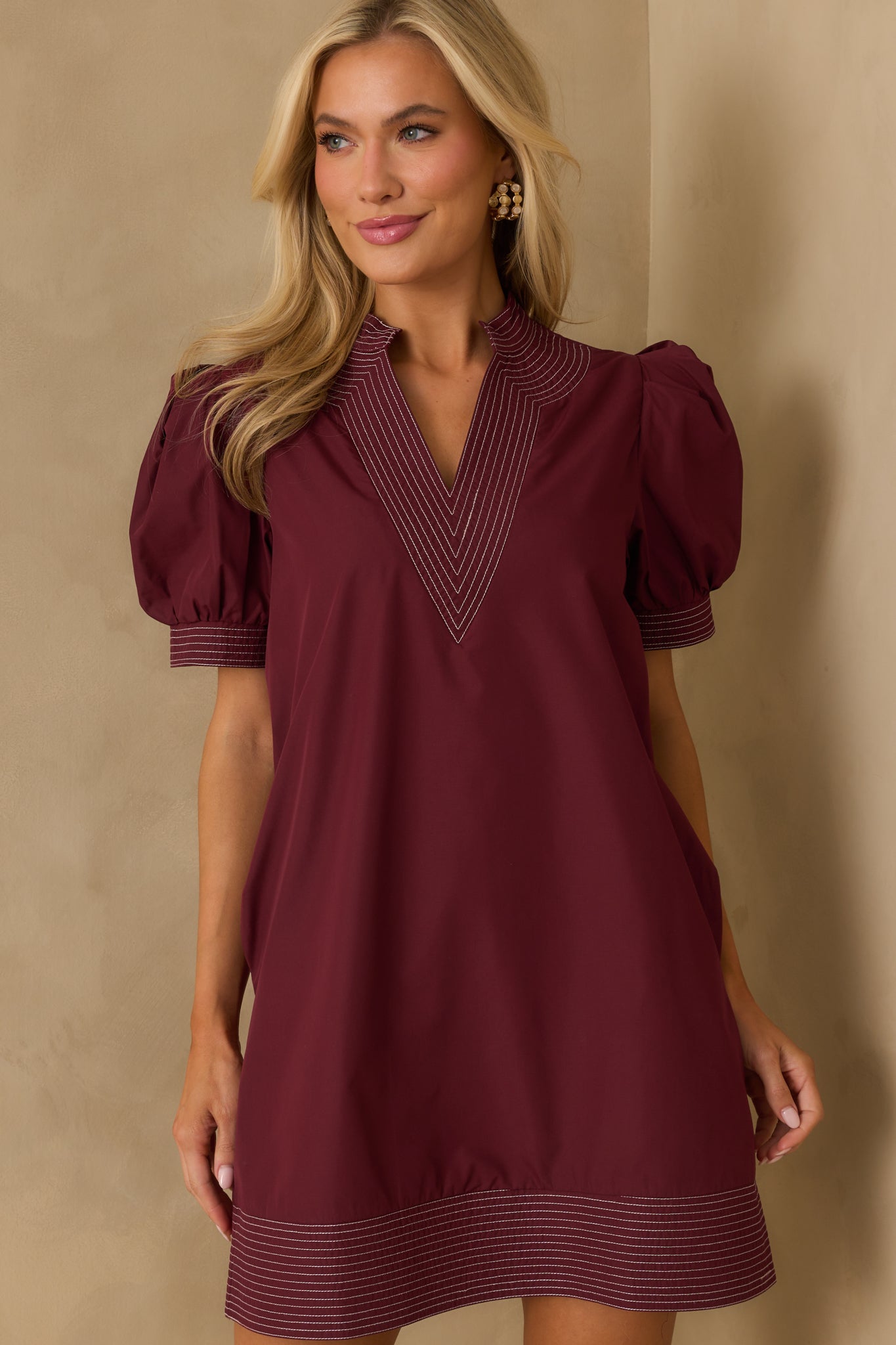 White topstitch trim detailing accenting the burgundy fabric.