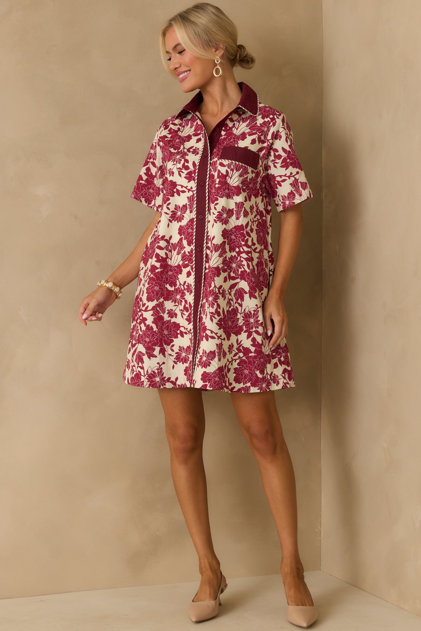 Burgundy floral mini dress accented with striped trim and a relaxed silhouette.
