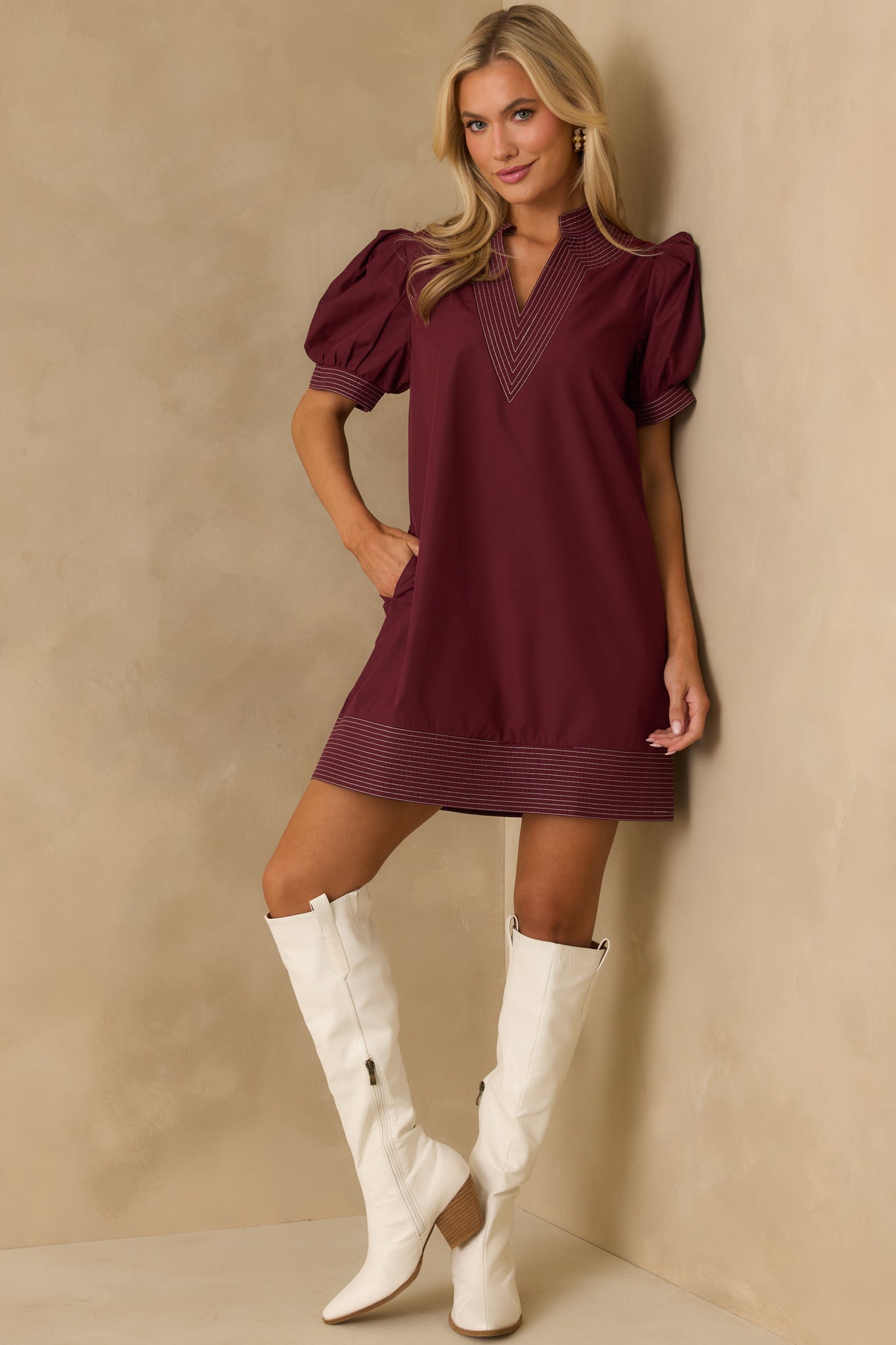 Burgundy mini dress with a notch v-neckline and short puff sleeves.
