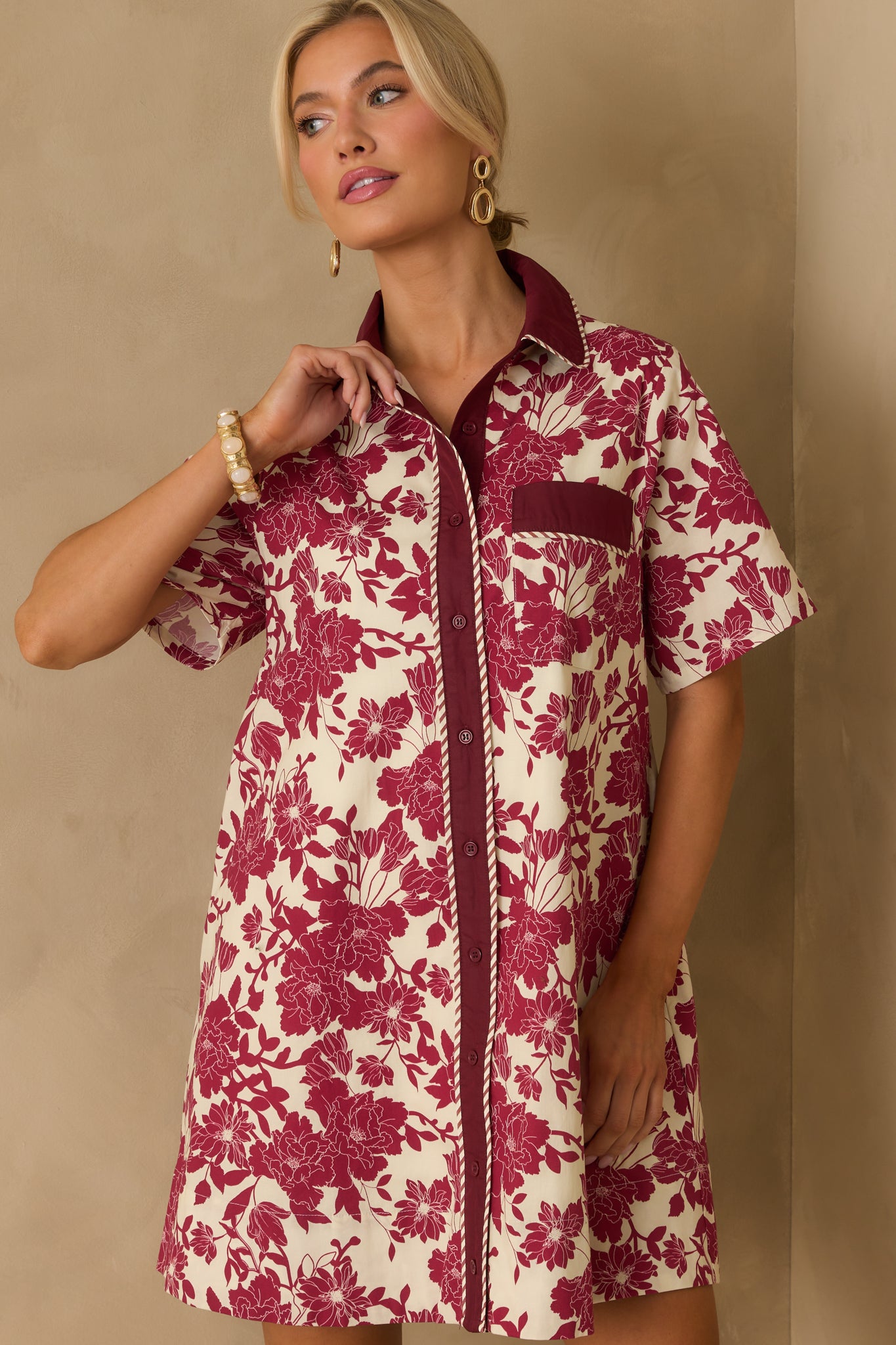 Solid burgundy placket with functional buttons against ivory floral fabric.