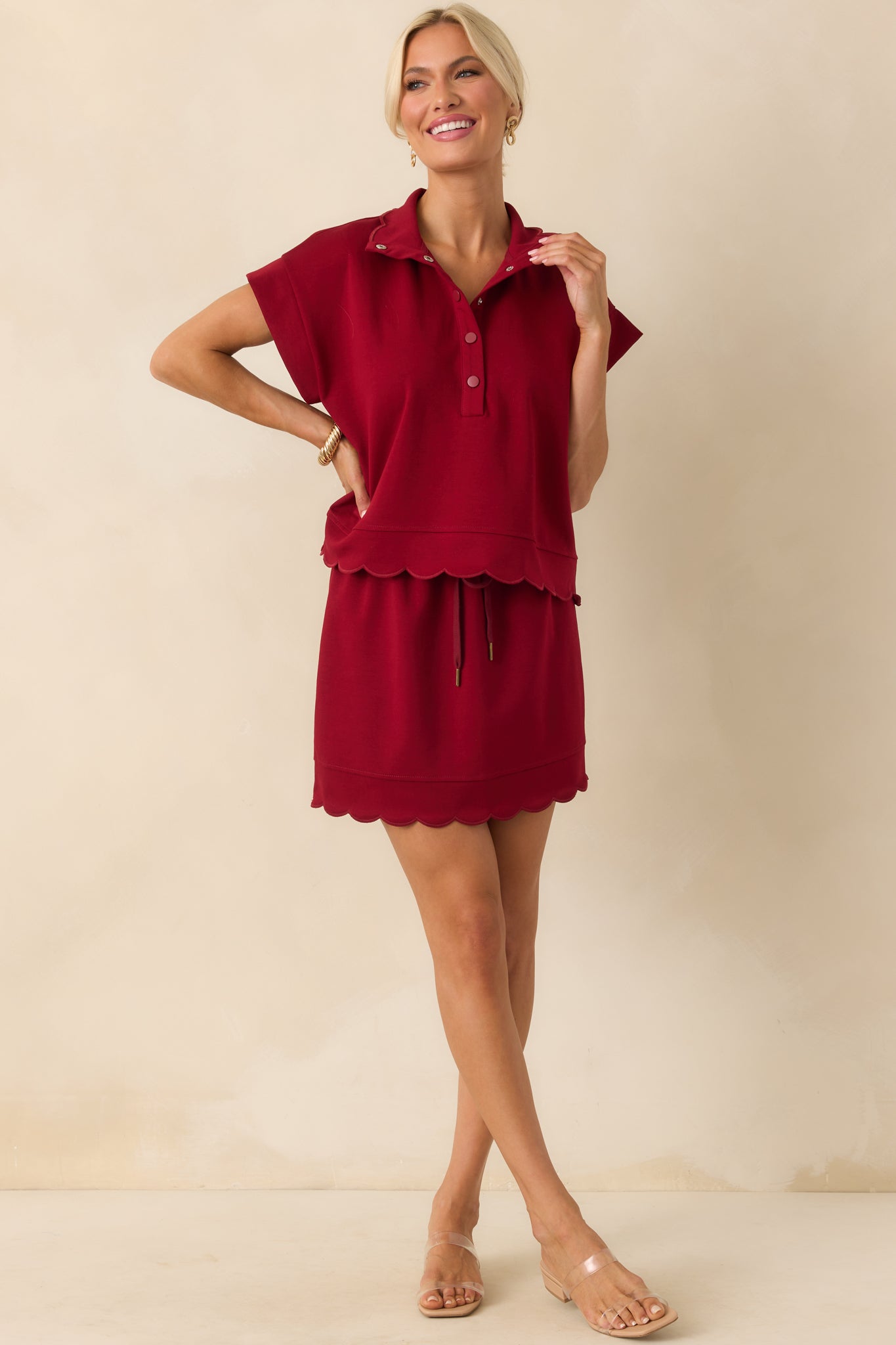 A full front view of the burgundy mini skirt showcasing the high rise and relaxed silhouette with an elastic waistband.