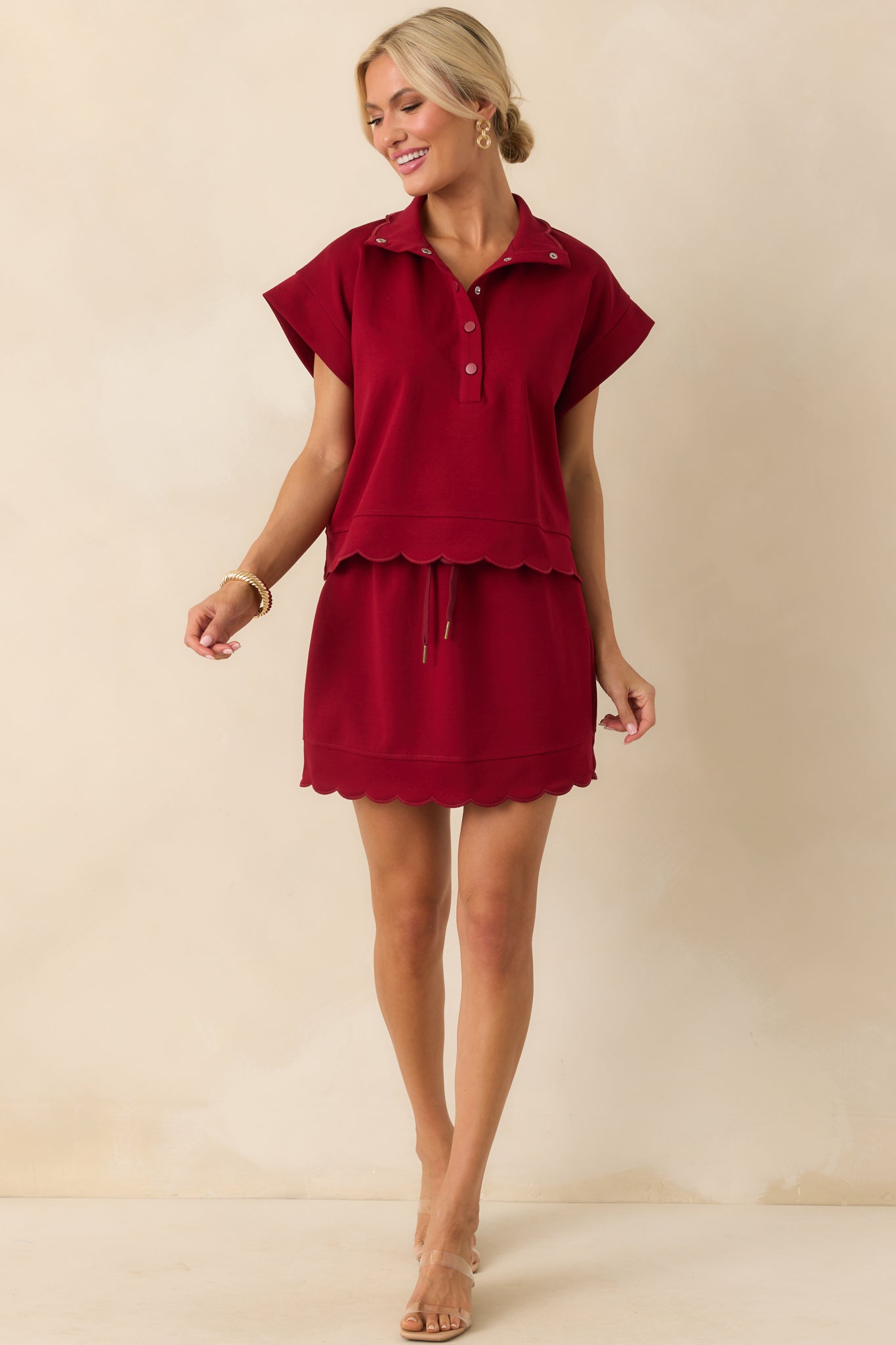 A front-facing full body shot emphasizing the overall fit and coverage provided by the built-in burgundy shorts.