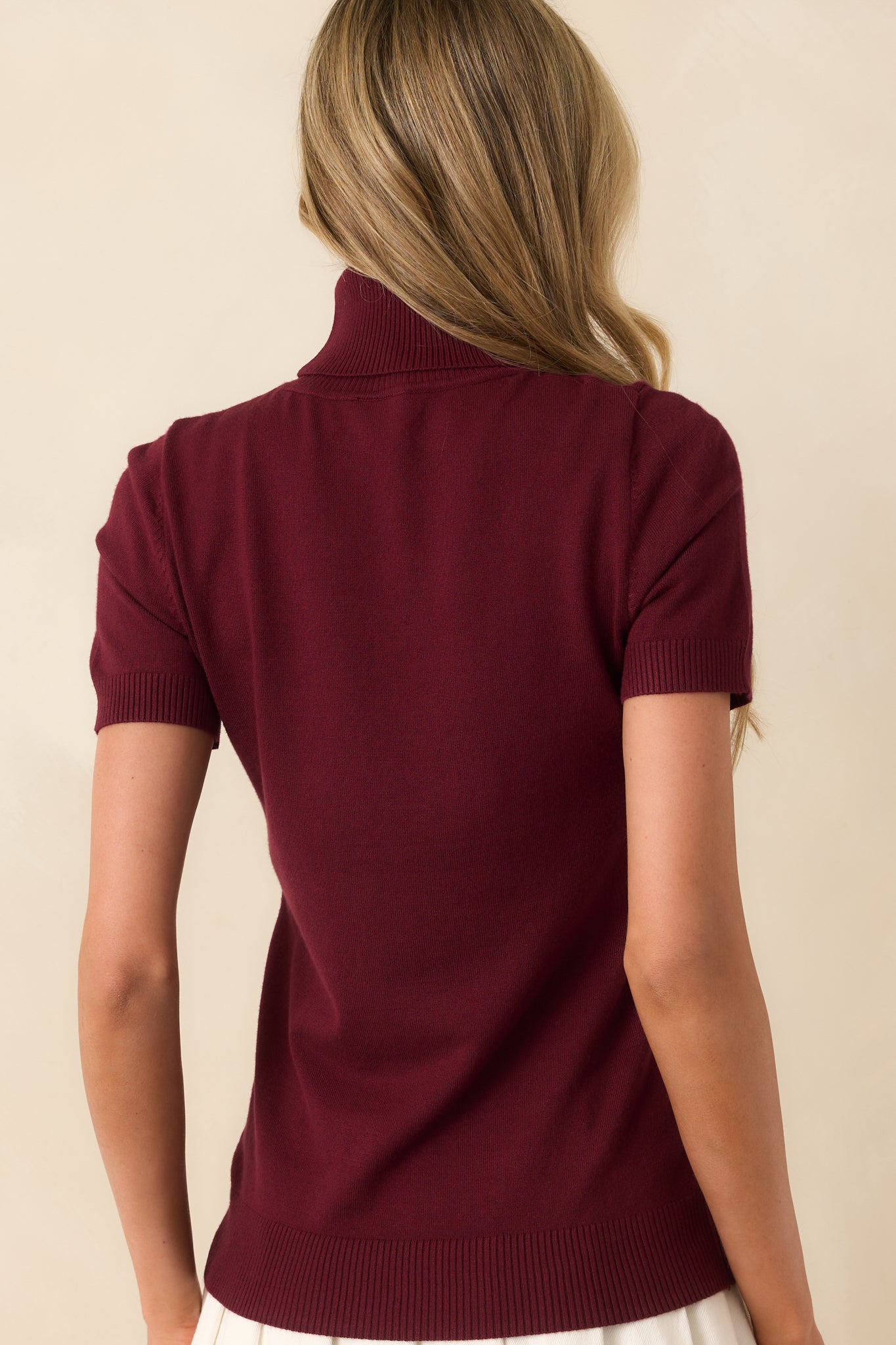 Rear view of the wine red ribbed sweater showing short sleeves and fitted silhouette.