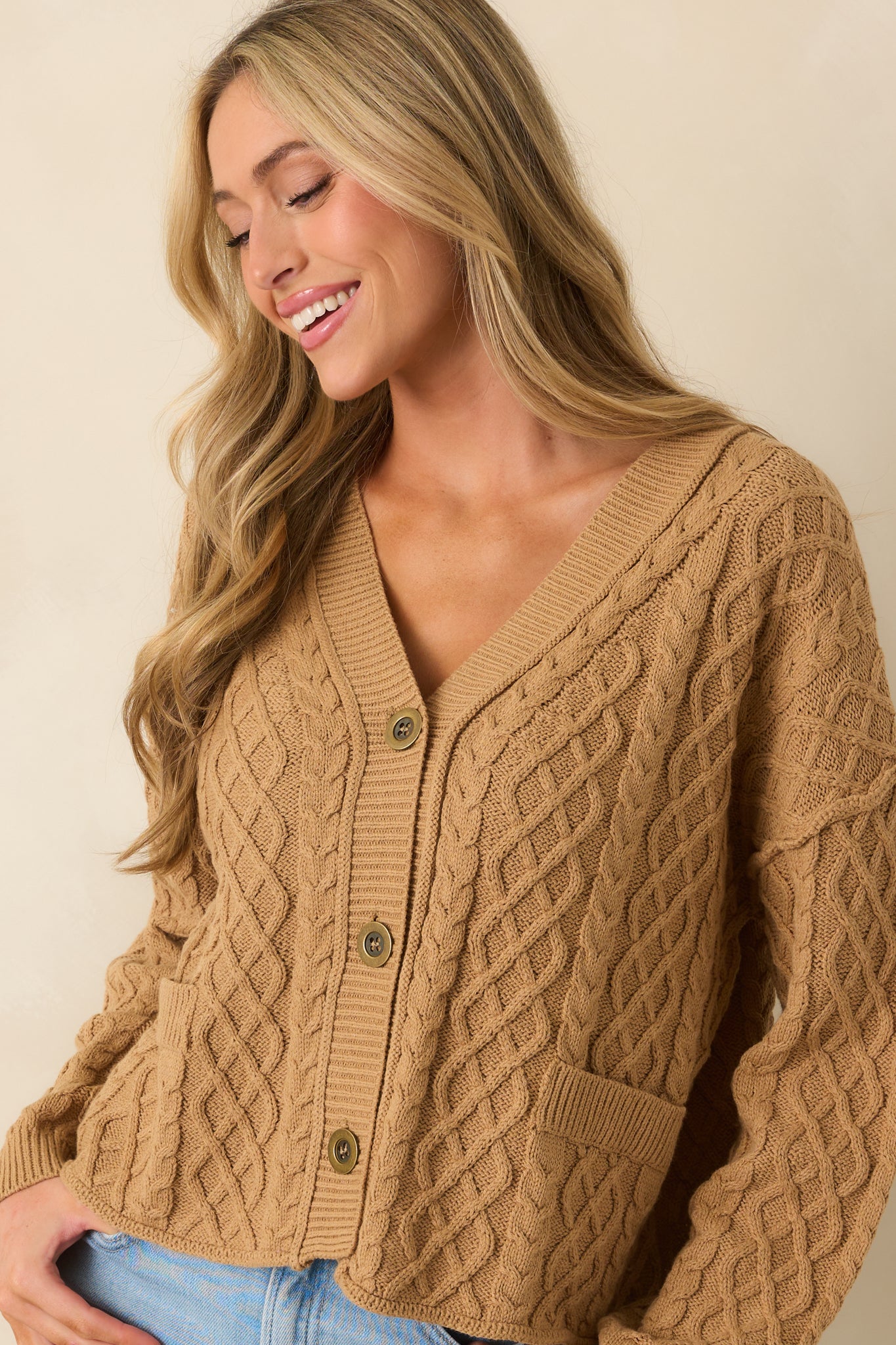 Close-up view of the long sleeve detailing and ribbed cuff of the cardigan.