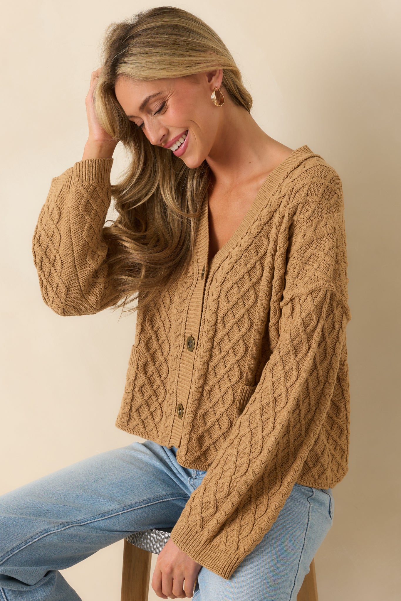 Cropped front view focusing on the v-neckline and functional button front of the cardigan.