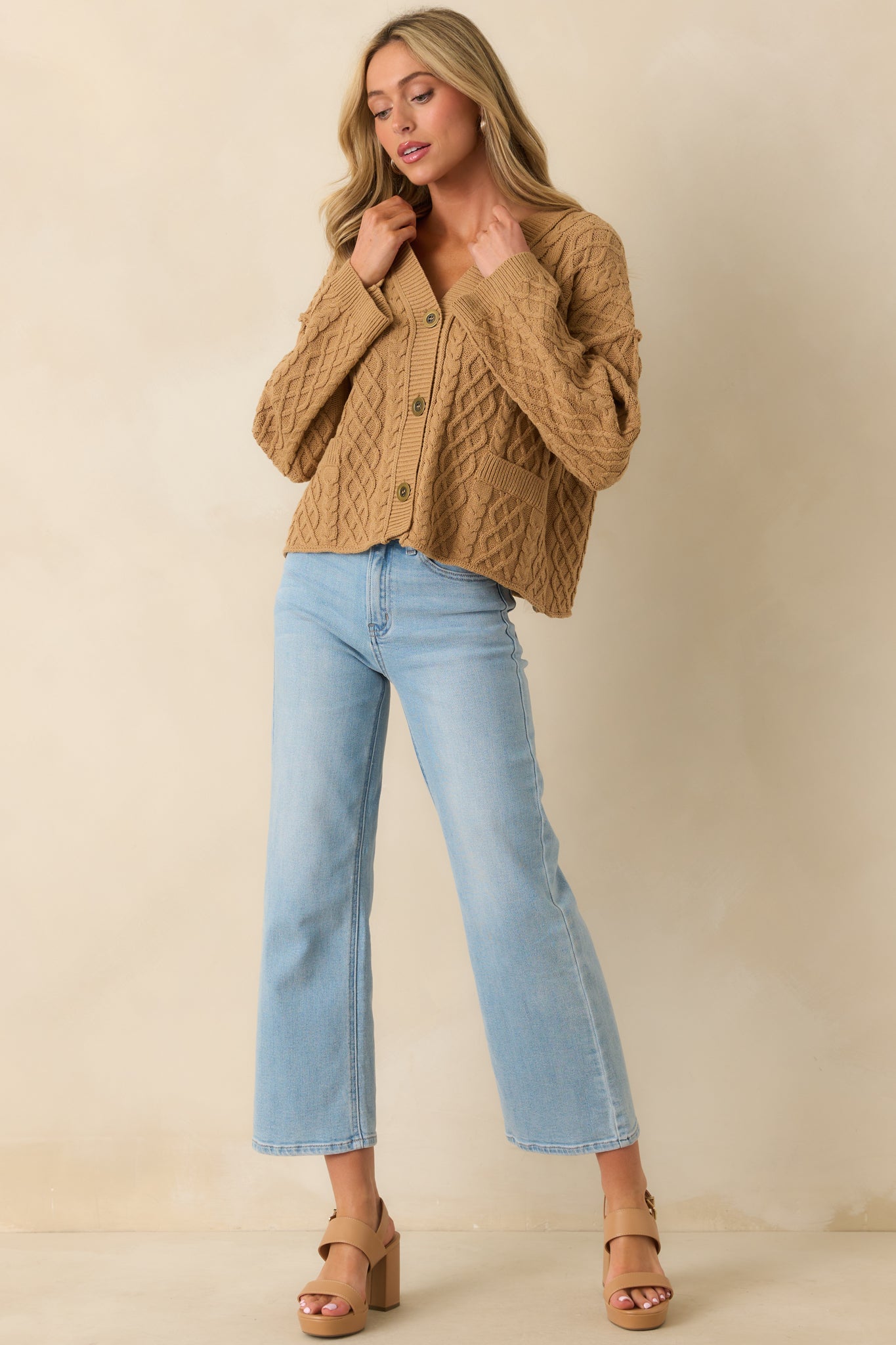 Front view showcasing the buttoned-up cardigan with a cozy cable knit design.