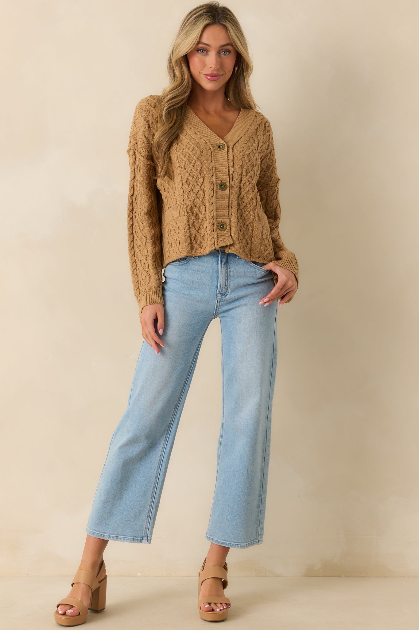 Full body shot highlighting the long sleeves and soft knit texture of the camel cardigan.