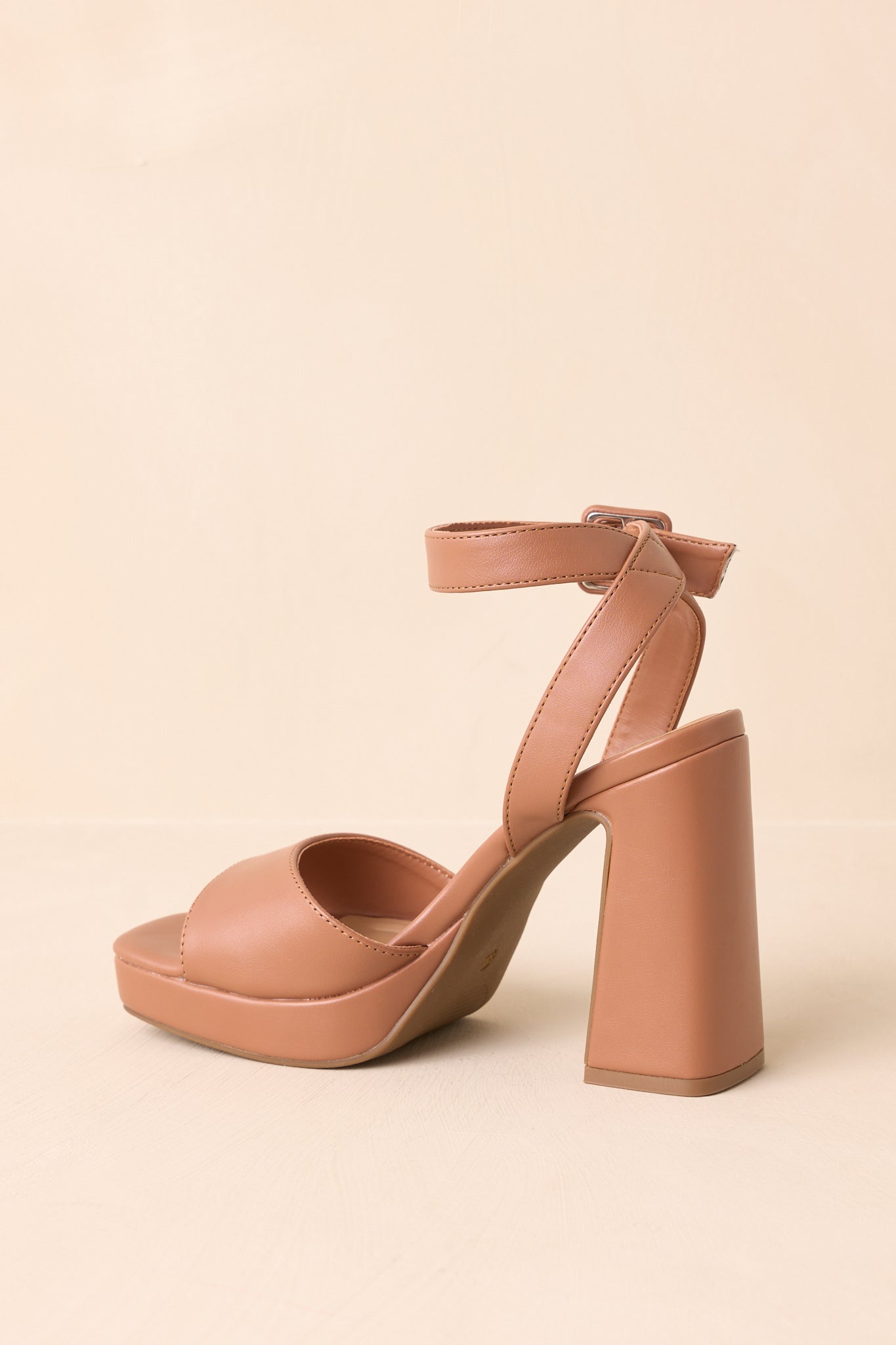 Cropped shot emphasizing the adjustable wide ankle strap with a covered buckle and pin closure.