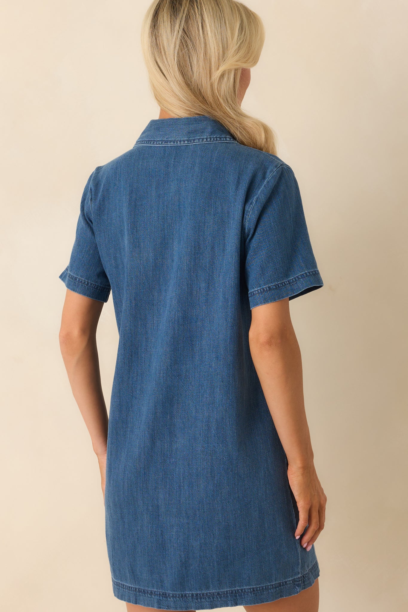 Rear view of the dress showing the simple back panel, soft shaping through the waist, and overall relaxed silhouette.