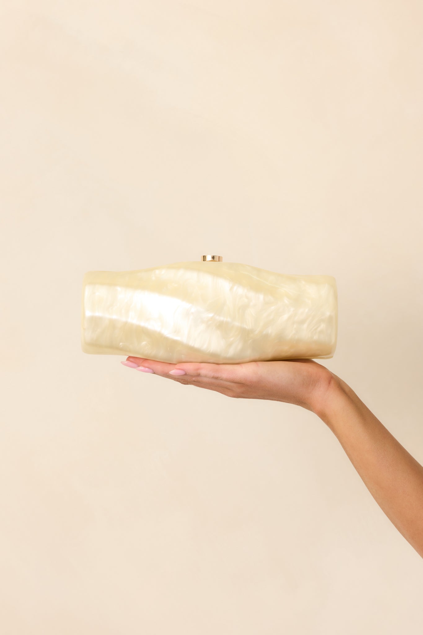 Cropped view of the spiral-textured clutch with the magnetic hinged closure visible at the top, showcasing its sculptural design.