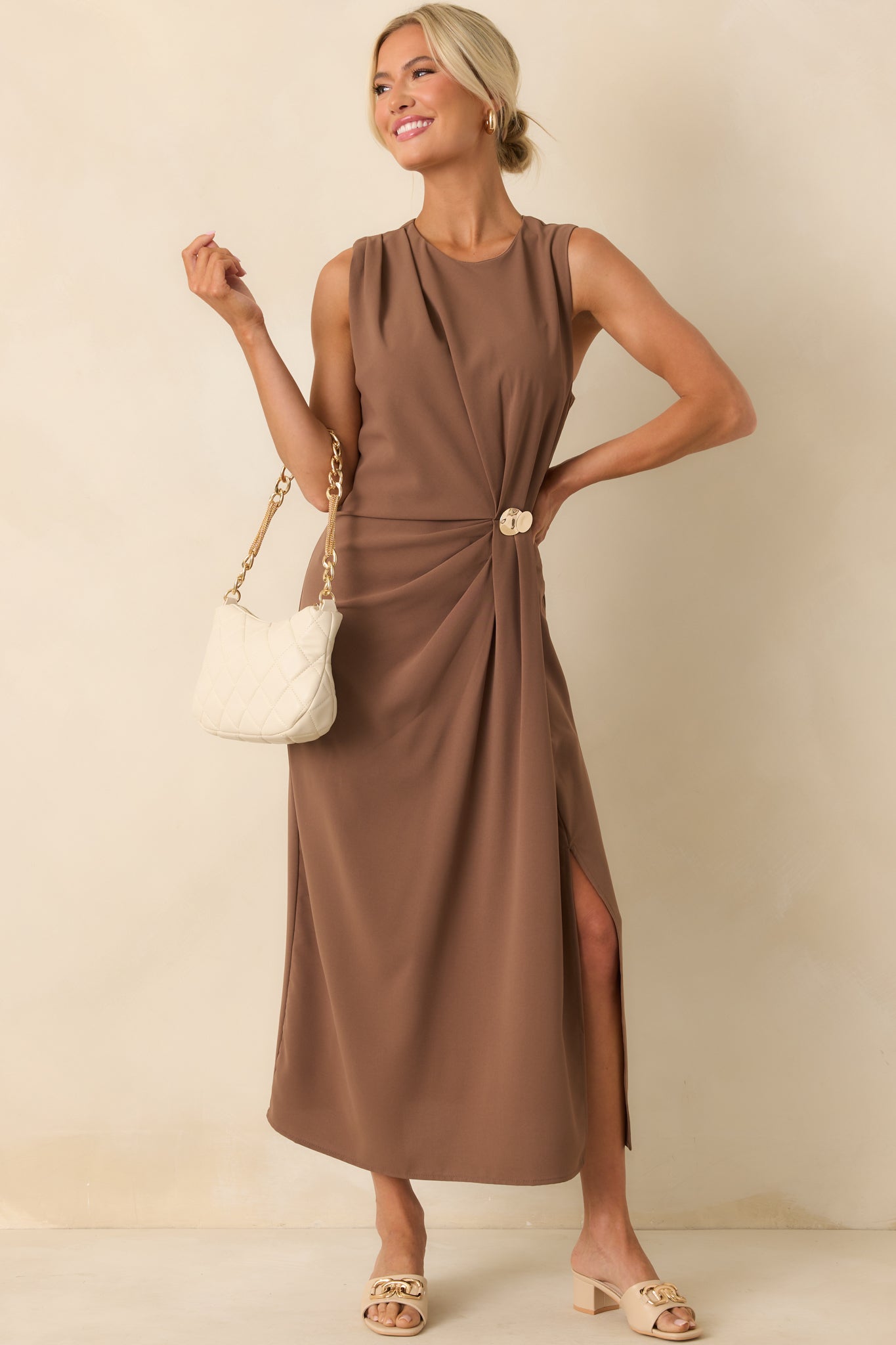 Front view of the light brown dress featuring a sleeveless cut, round neckline, and softly draped silhouette.