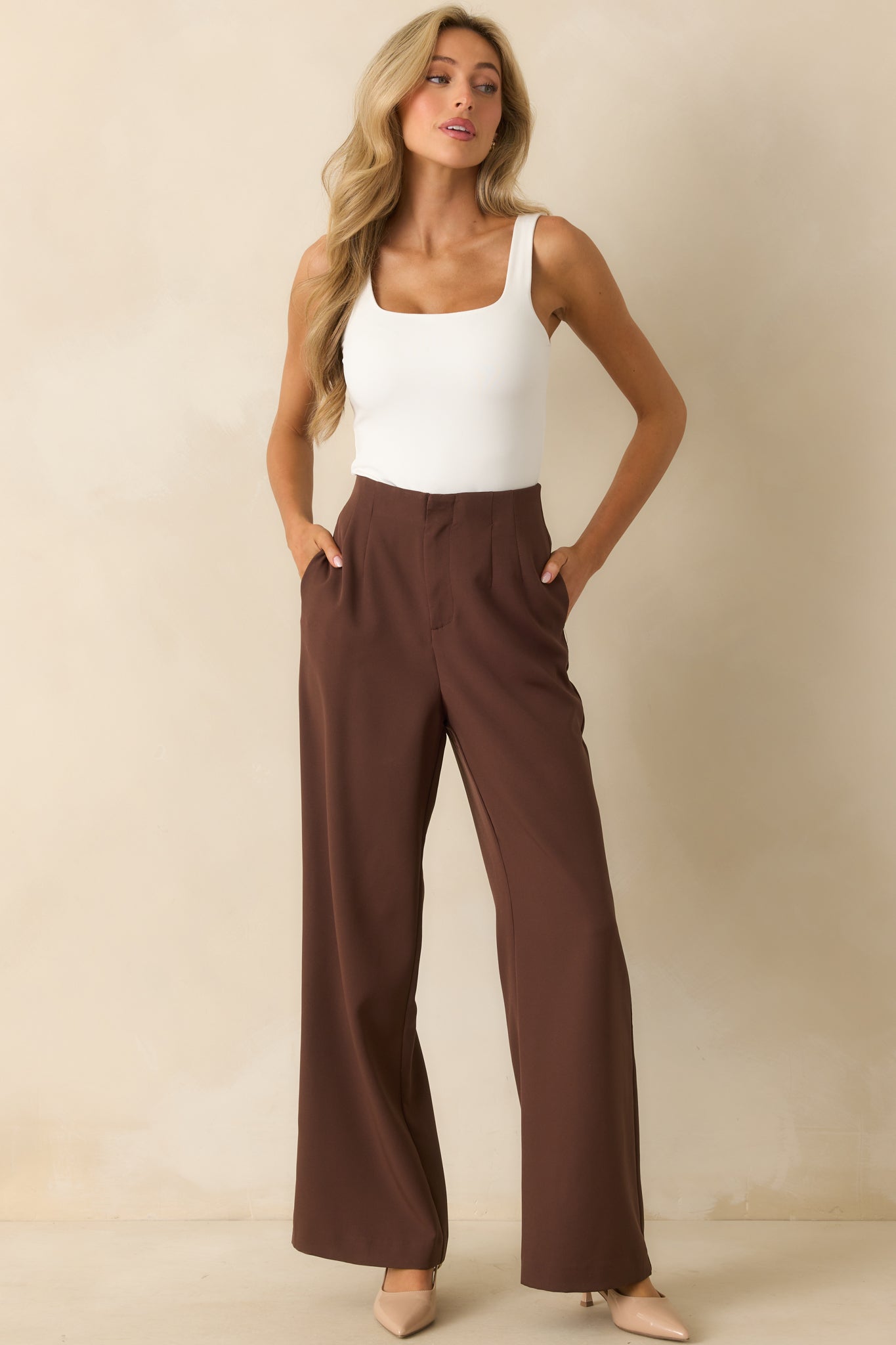 Full body view of the chocolate brown pants styled with a high rise fit and smooth front design.
