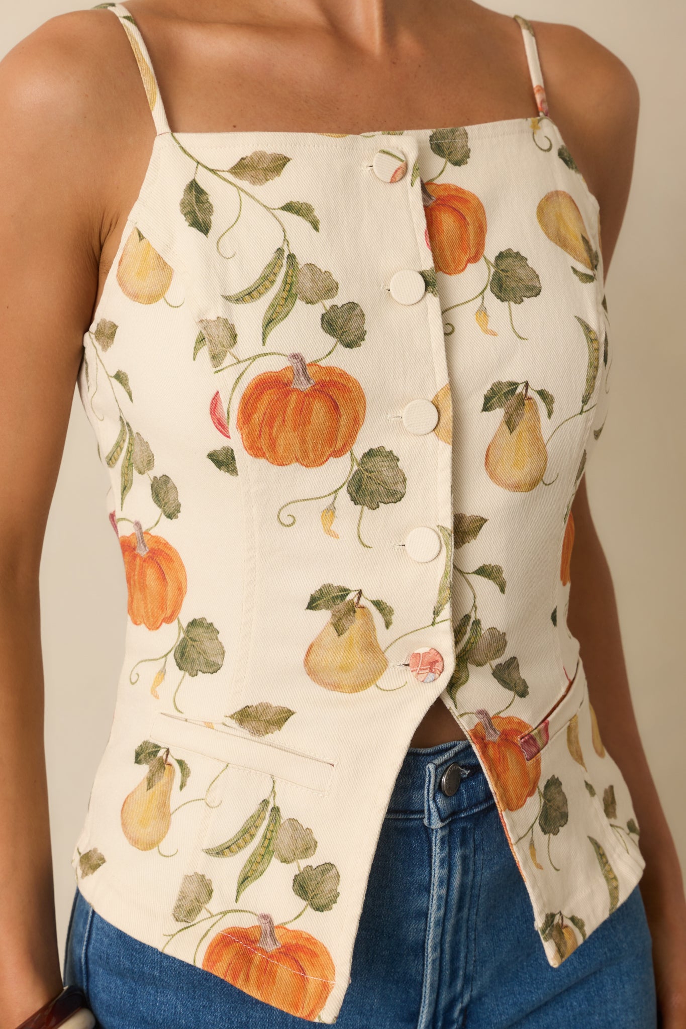 Close-up detail of ivory top’s vegetable garden print, paneled seams, and textured button closure.