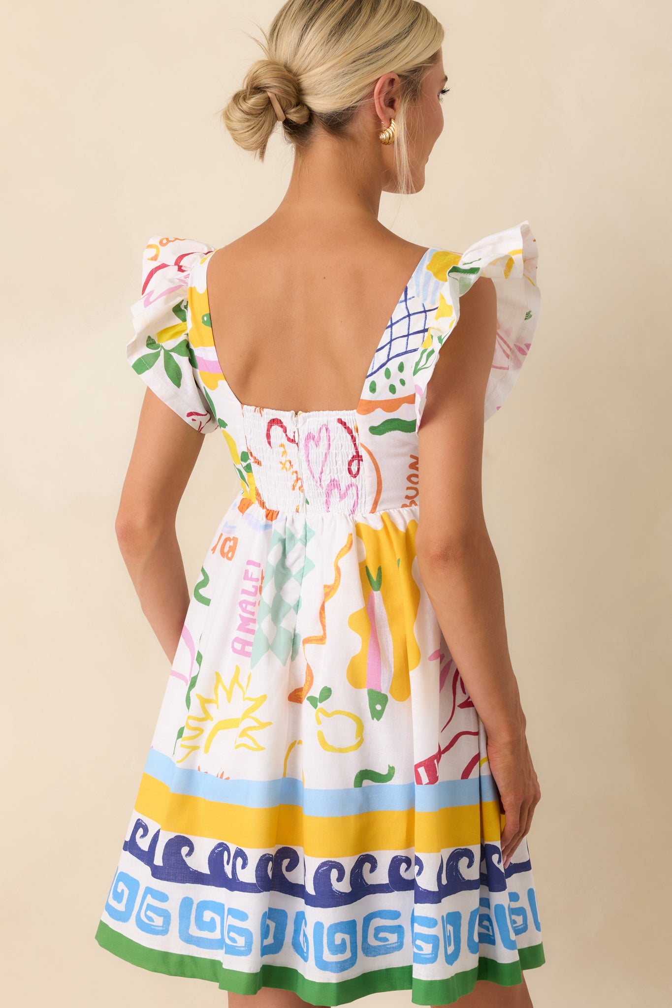 A view from behind showing the smocked back panel and hidden zipper closure, with the vibrant multicolor print continuing across the back of the dress.
