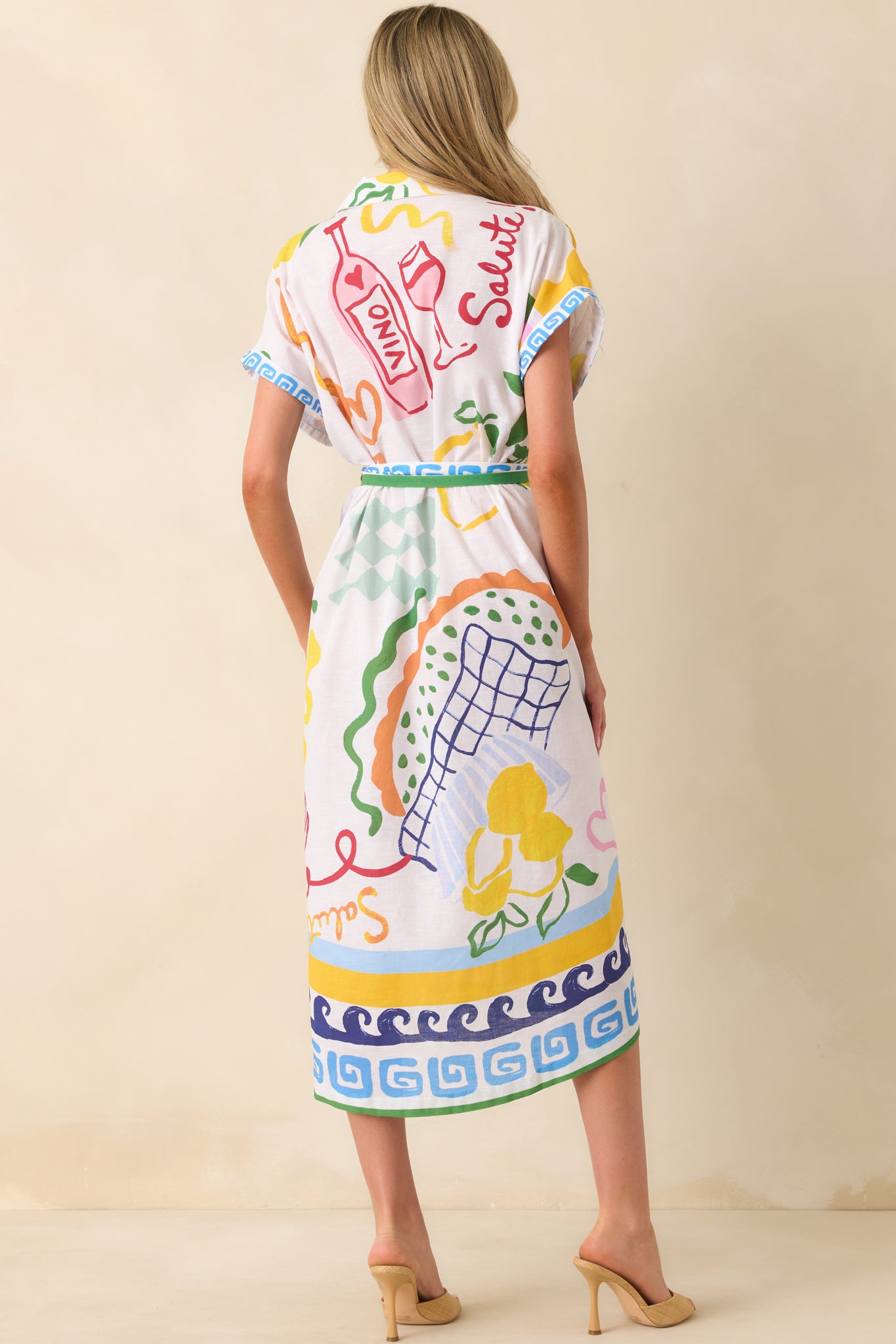 A view from behind of the midi dress featuring the full multicolor print, cuffed sleeves, and placement of the self-tie belt at the waist.