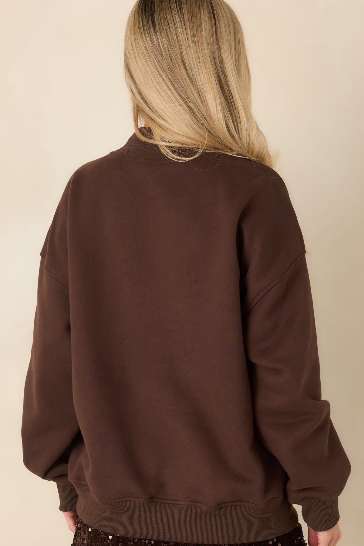 Back view of cocoa brown mock neck sweatshirt with a plain back, dropped shoulders, and ribbed cuffs and hem.