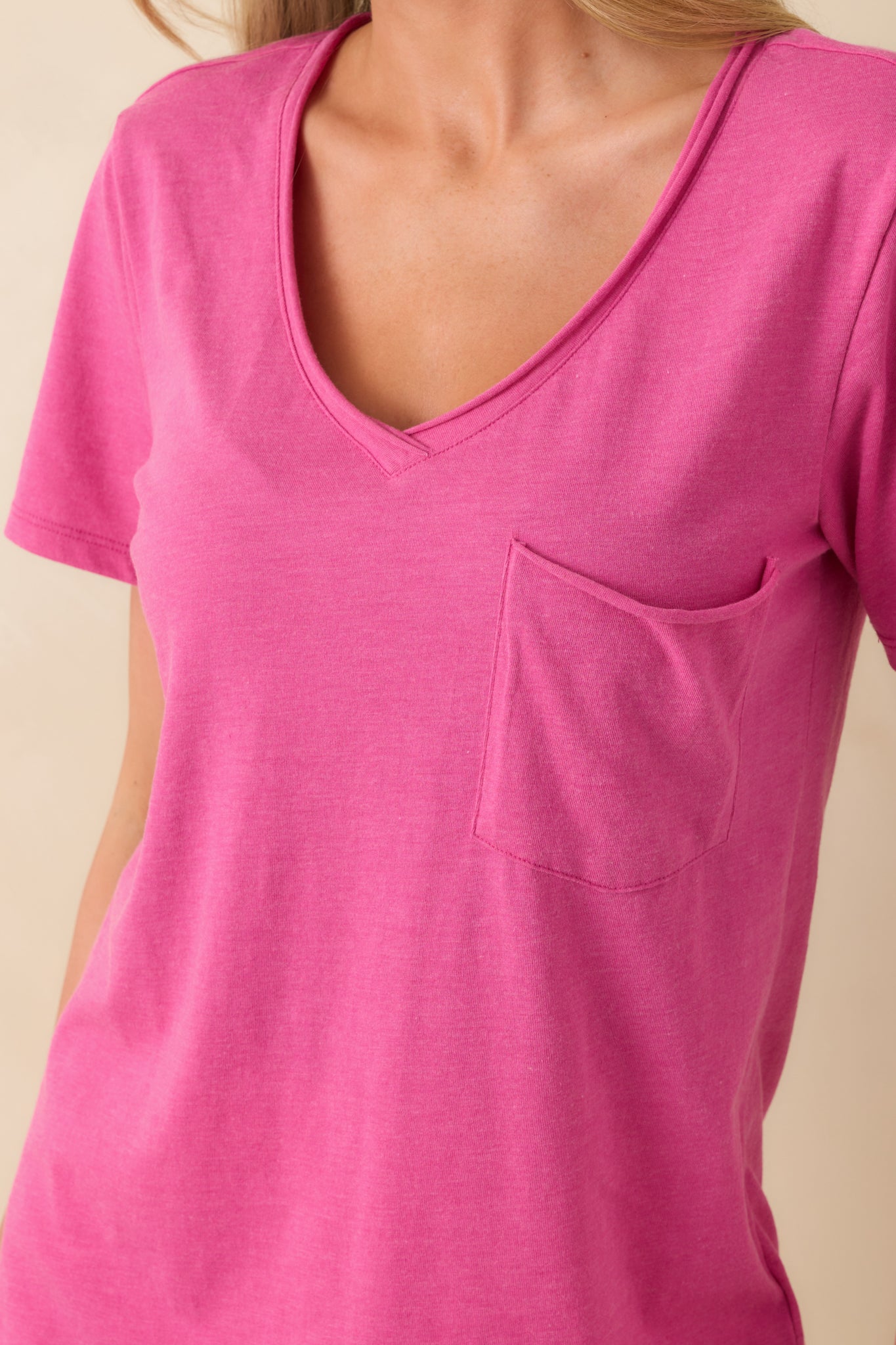 Close-up of the v-neckline and surrounding fabric, showing the rolled hem detail and breathable cotton blend texture.