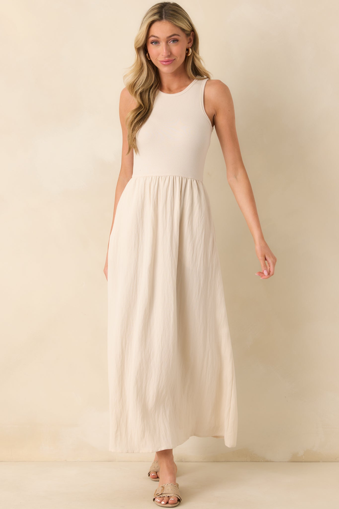Front view of a beige midi dress featuring a ribbed cotton bodice, crew neckline, and textured skirt with functional pockets.