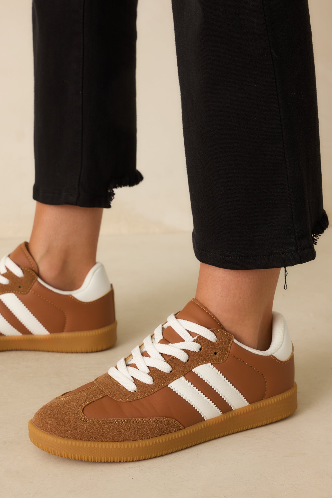 A cropped shot of the sneakers highlighting the caramel brown faux leather and faux suede mix.