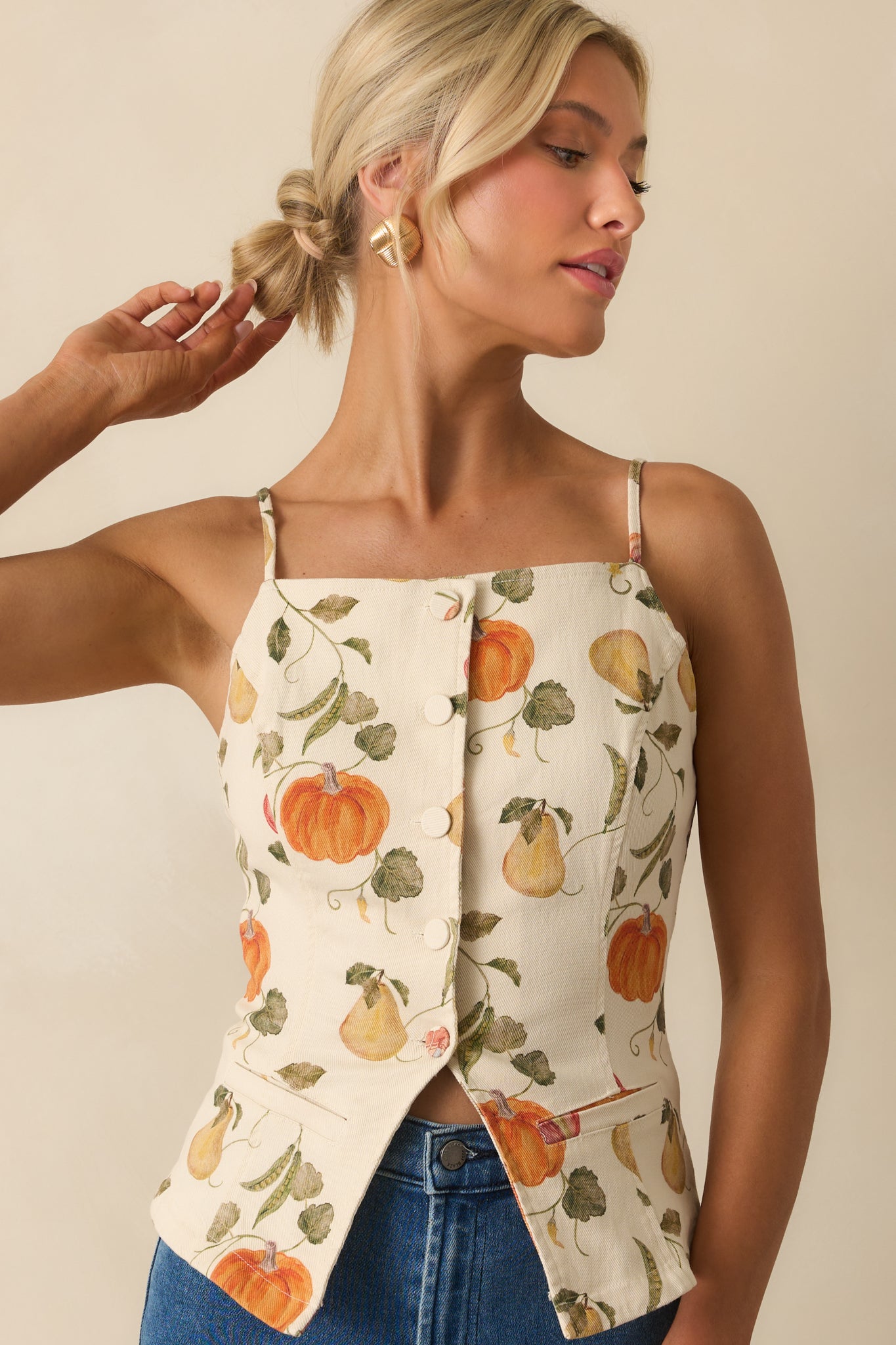 Close cropped image of ivory paneled blouse with fitted tailoring and decorative buttons.