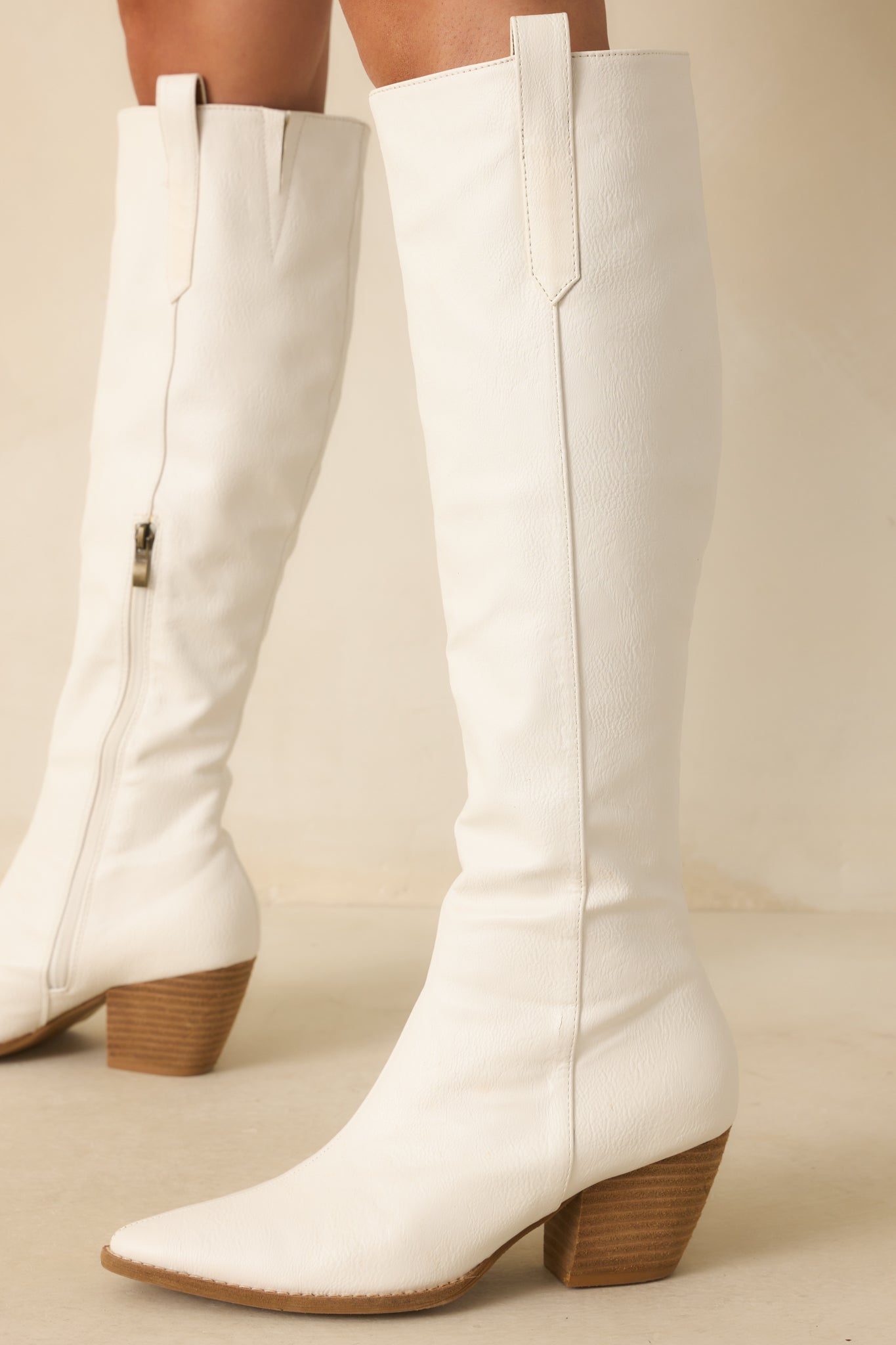 Cropped shot of the Western-inspired boots, focusing on the side zipper and sleek white finish.