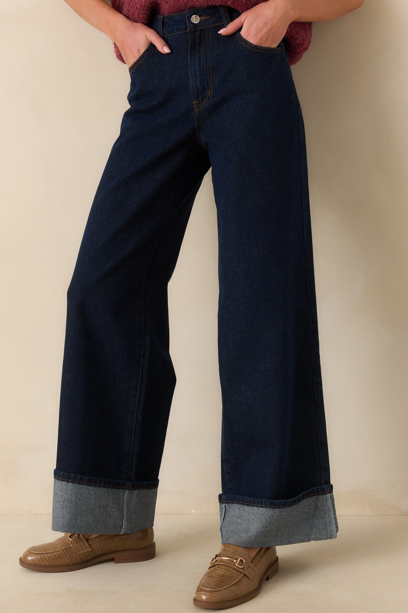 Cropped front view focusing on the high rise waistband, button zipper closure, and front pockets.