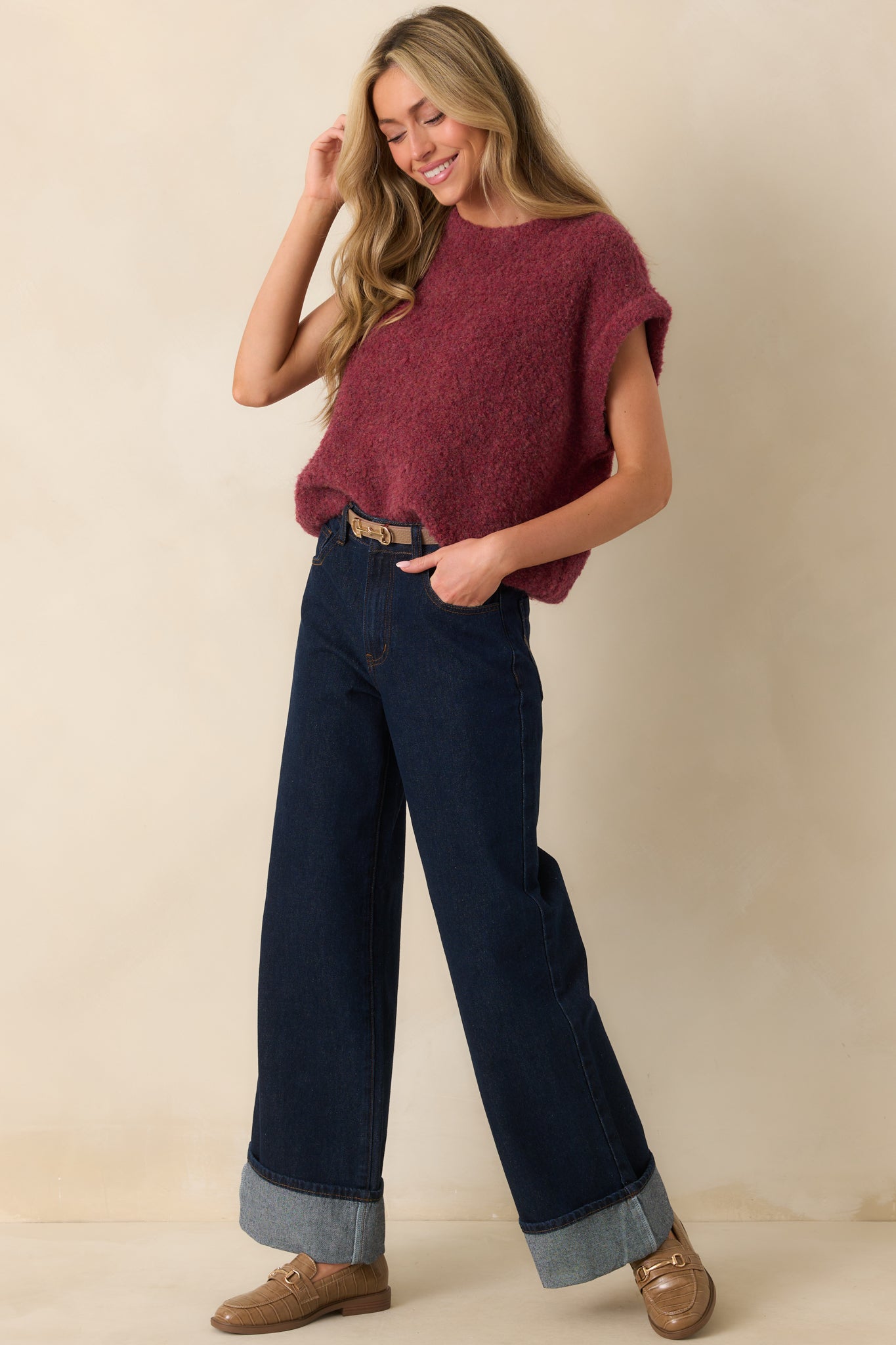 Front view of dark wash jeans with a high rise waist, functional five-pocket design, and sewn bottom hem cuffs.