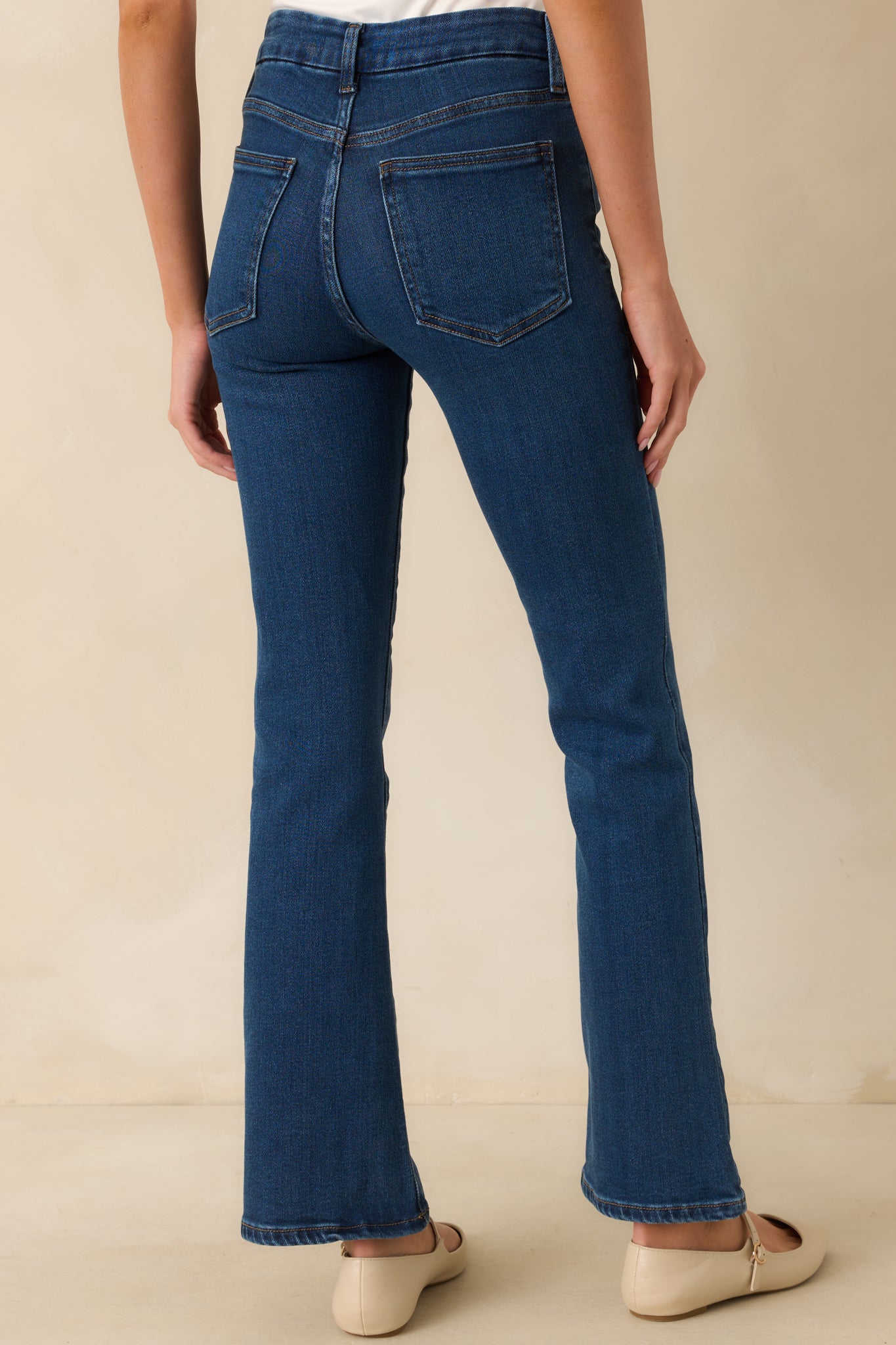 A back view of the dark wash jeans featuring a five-pocket design, high-rise fit, and straight leg silhouette.