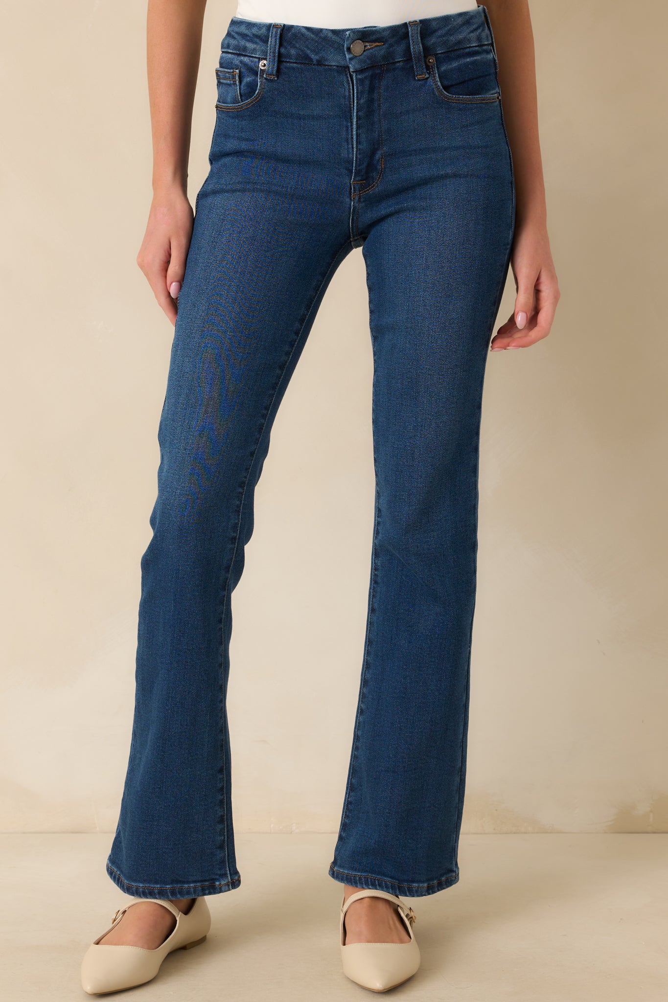 A cropped front view of the jeans focusing on the zipper button closure and waistband.