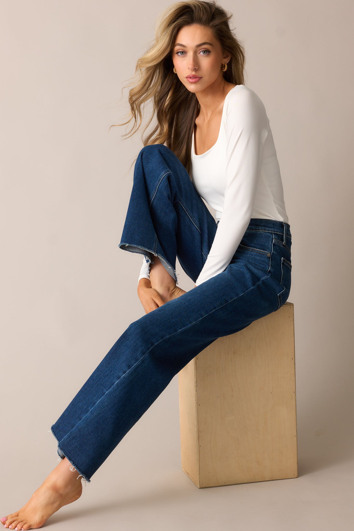 Dark wash high-waisted jeans with a wide straight-leg fit, functional pockets, and a raw bottom hem.