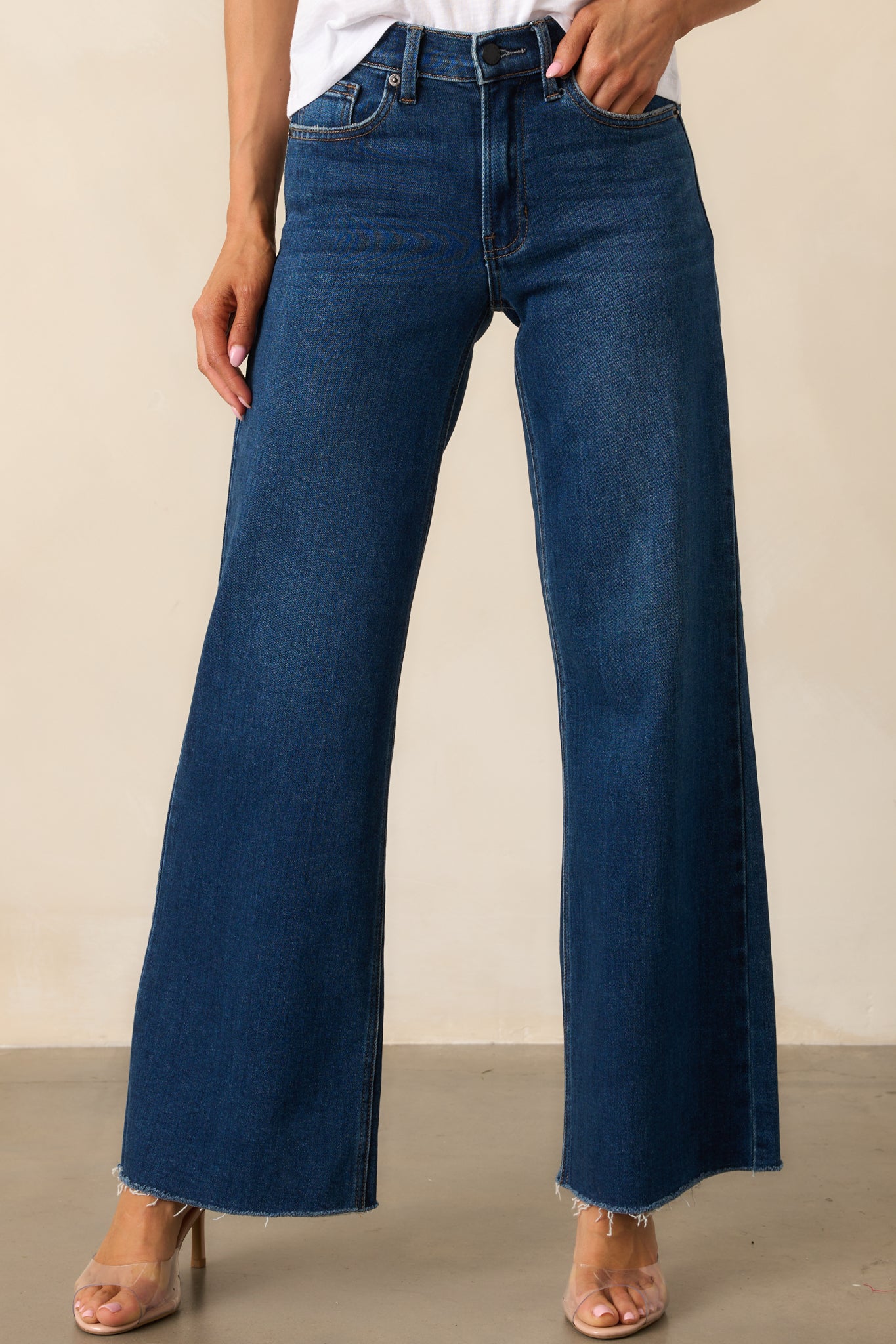The wide straight-leg fit of these dark wash jeans offers a timeless and versatile look.