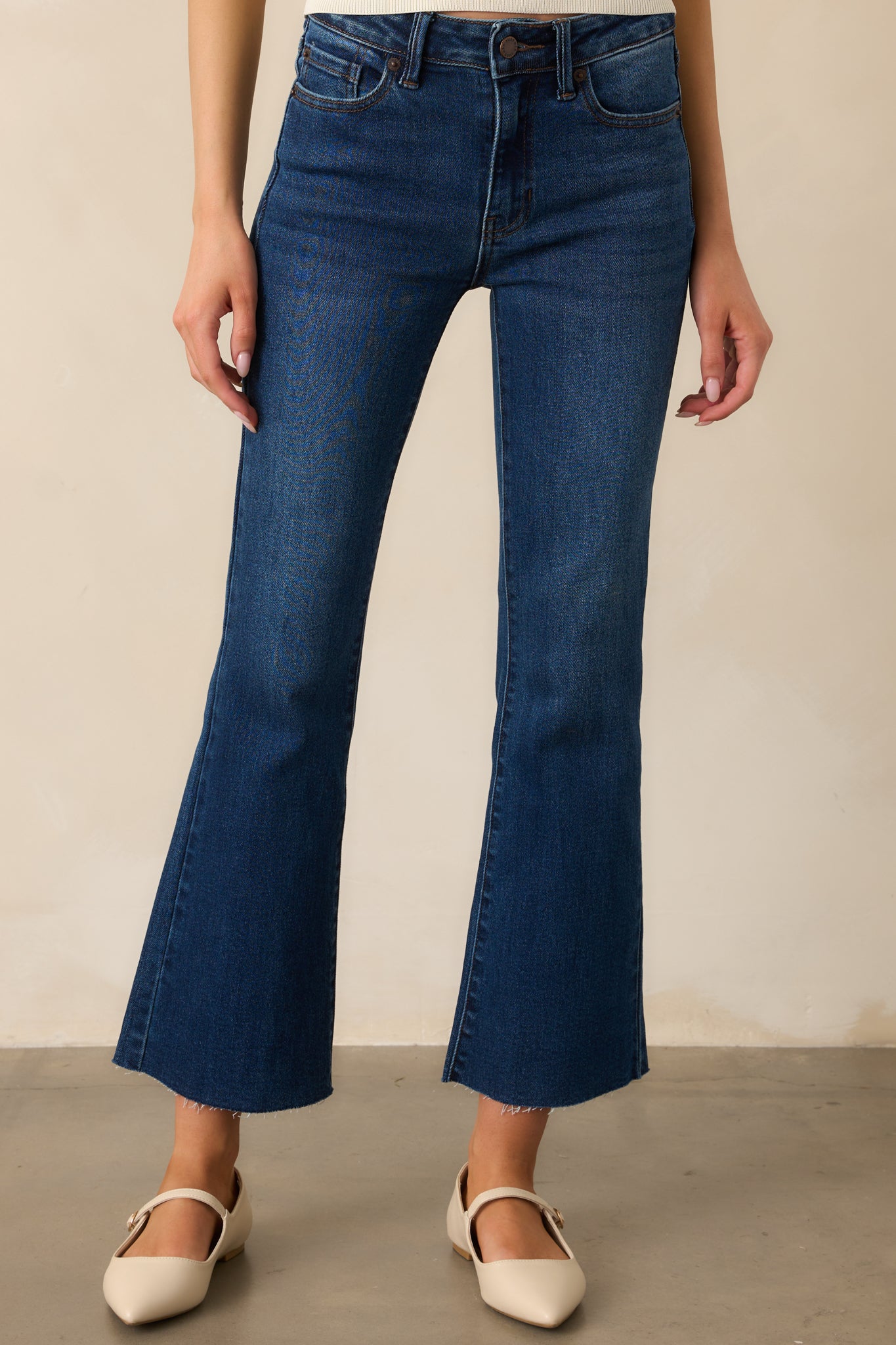 Detail of the flared leg on the dark wash jeans, showcasing the smooth fabric and structured shape for a flattering fit.