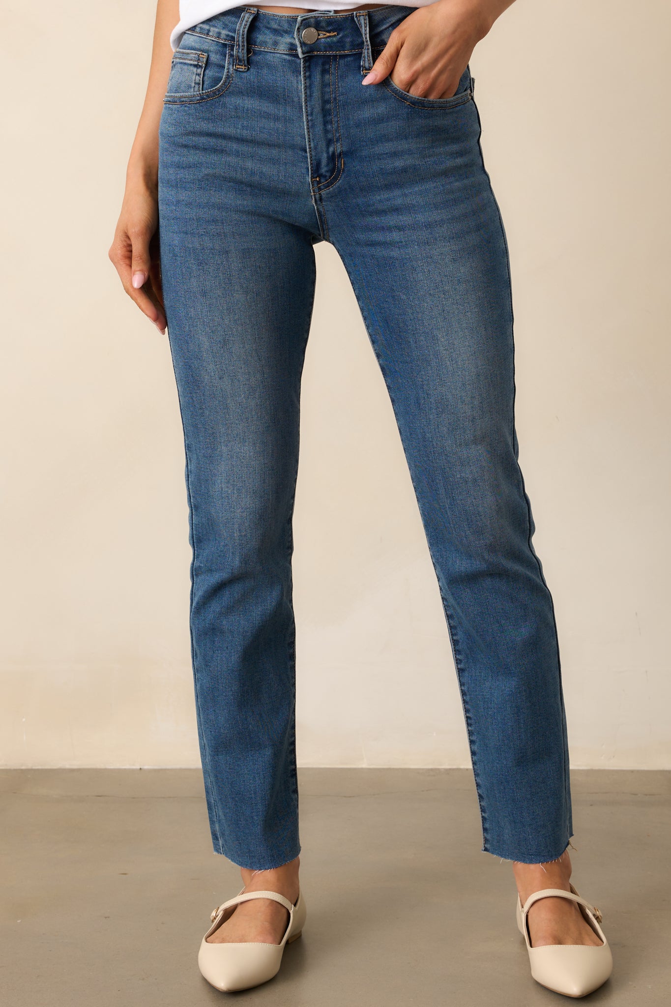 A cropped view focusing on the waistband, belt loops, and functional front pockets of the dark wash jeans.