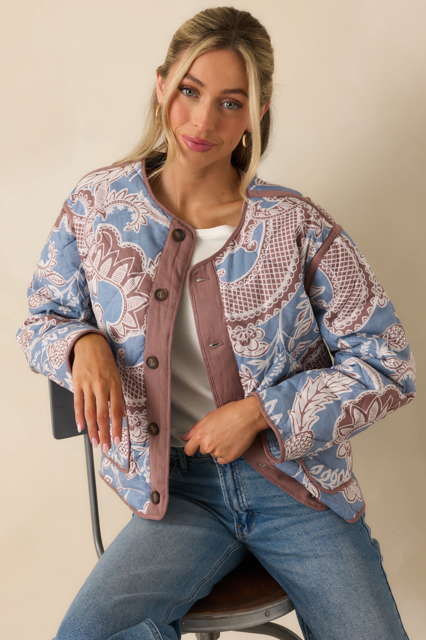 Highlight of the jacket’s neckline and top buttons, framed by the mauve trim.