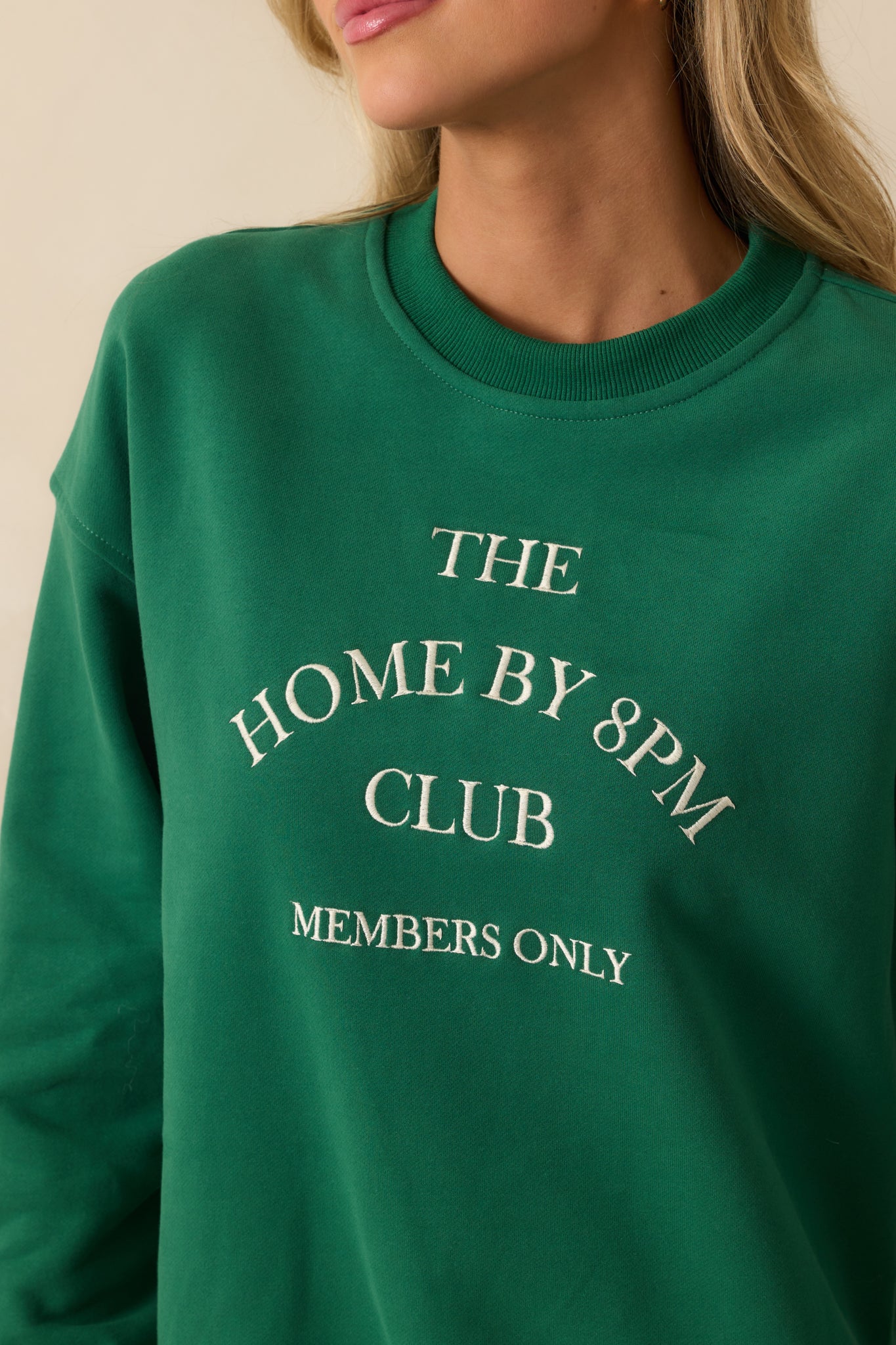 Detailed embroidery of “The Home By 8PM Club Members Only” on the sweatshirt’s front.