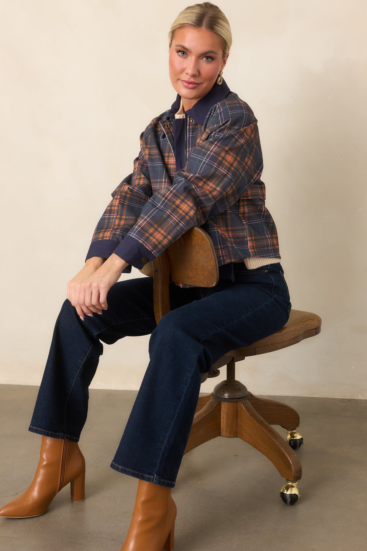 Relaxed navy plaid jacket featuring warm brown, pink, and blue tones, solid navy trim, and raglan sleeves.