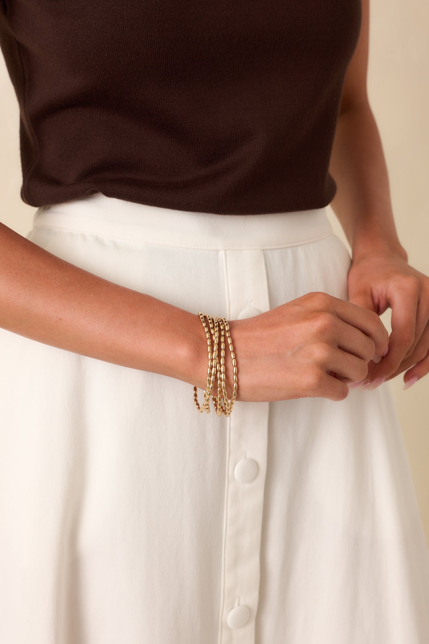 Full view of all five bracelets being worn and styled, showcasing the uniform oval bead shape and cohesive set styling.