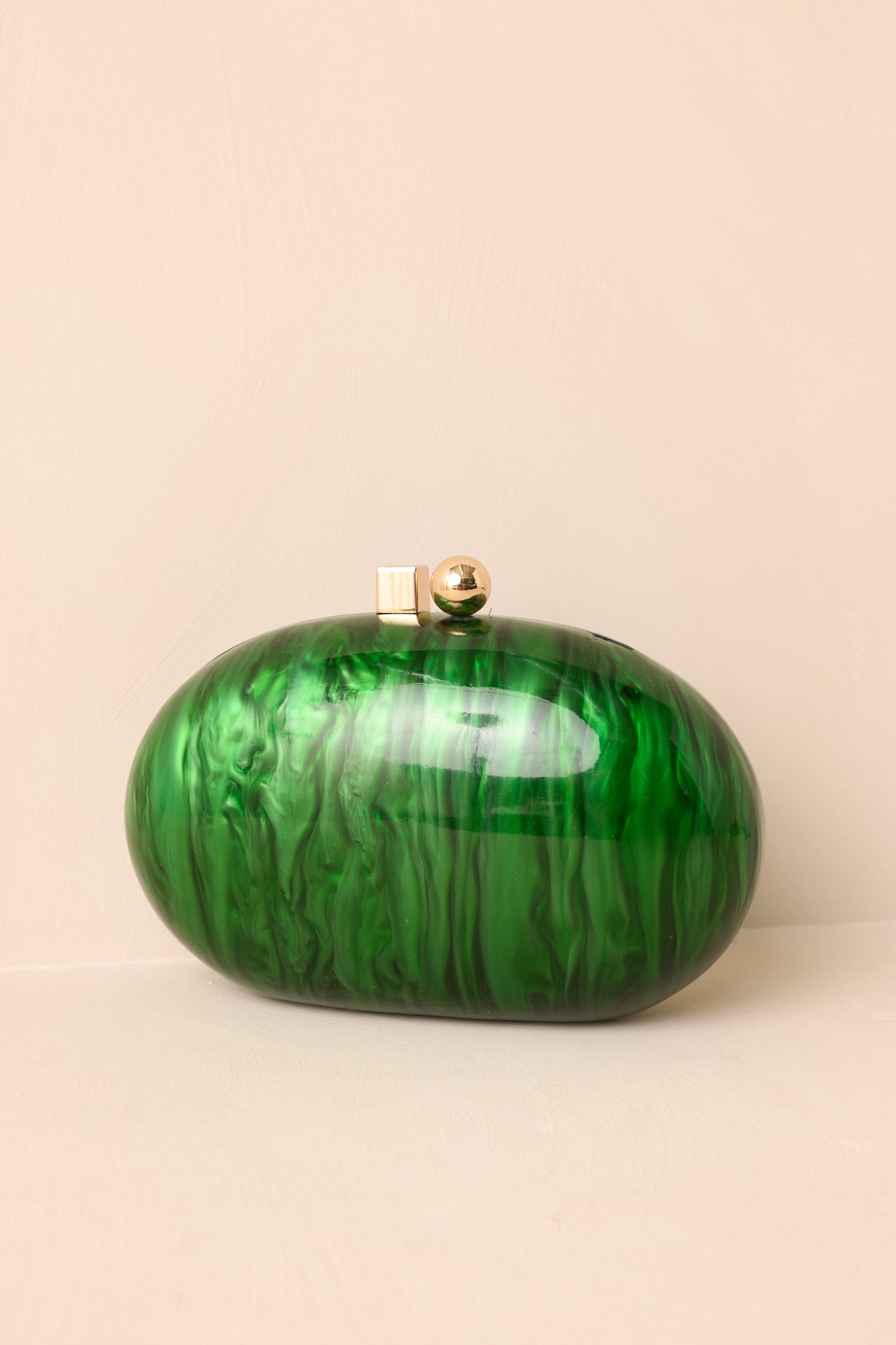 Close view of the emerald clutch highlighting its pearlescent finish and sleek box clasp closure.