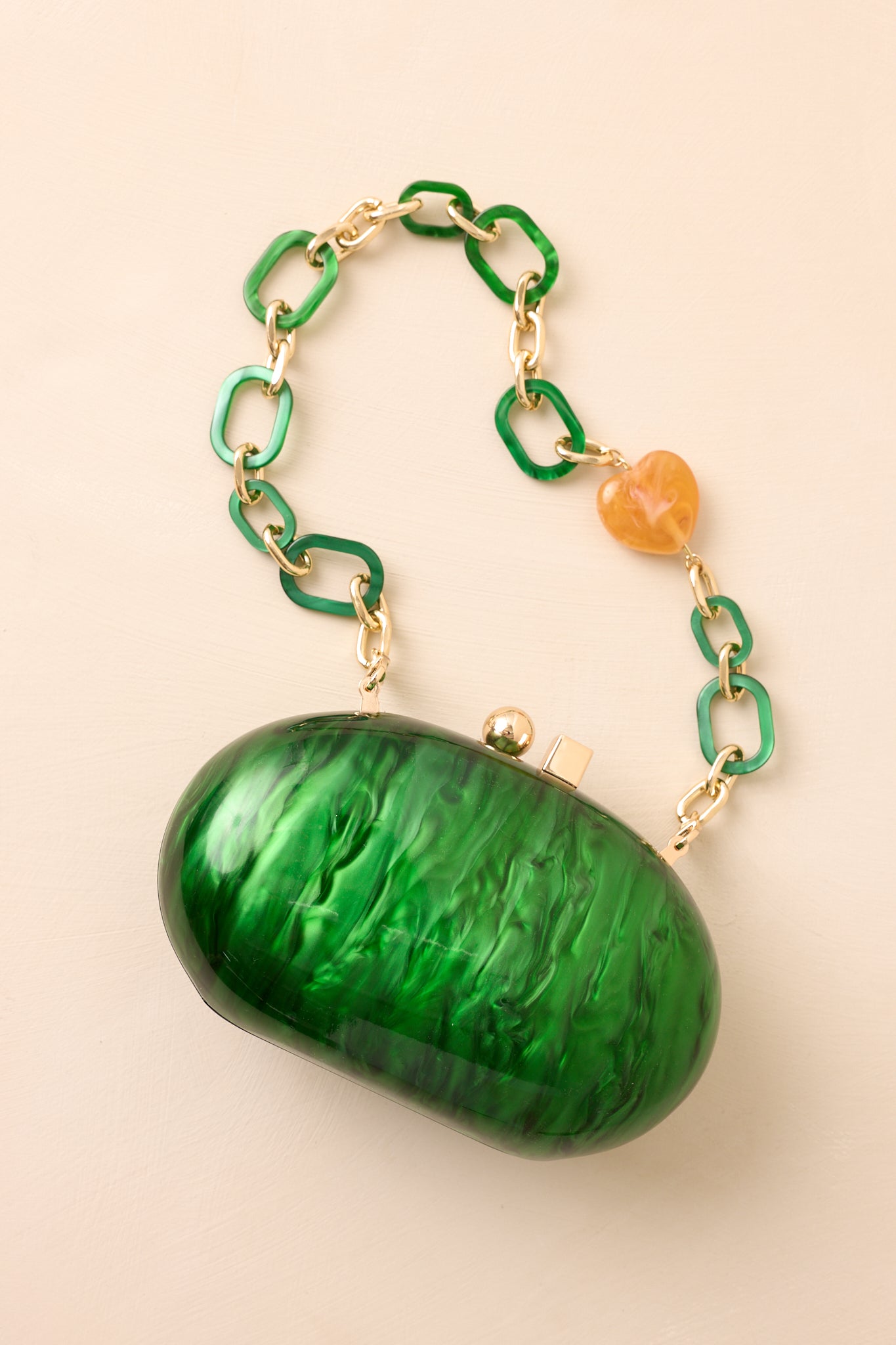 Emerald green clutch with a glossy pearlescent shine and gold box clasp, shown with its elegant structured shape.