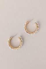 Side view of these Elegant earrings adorned with gold hardware, faux pearls, and shimmering rhinestones, complete with secure post backings for effortless wear.