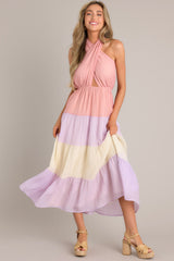 Pink dress featuring a self-tie halter neckline with a back tie closure, an alluring open back, an elastic band at the back of the bust for a comfortable fit, an elastic waistband, and a flowing skirt.