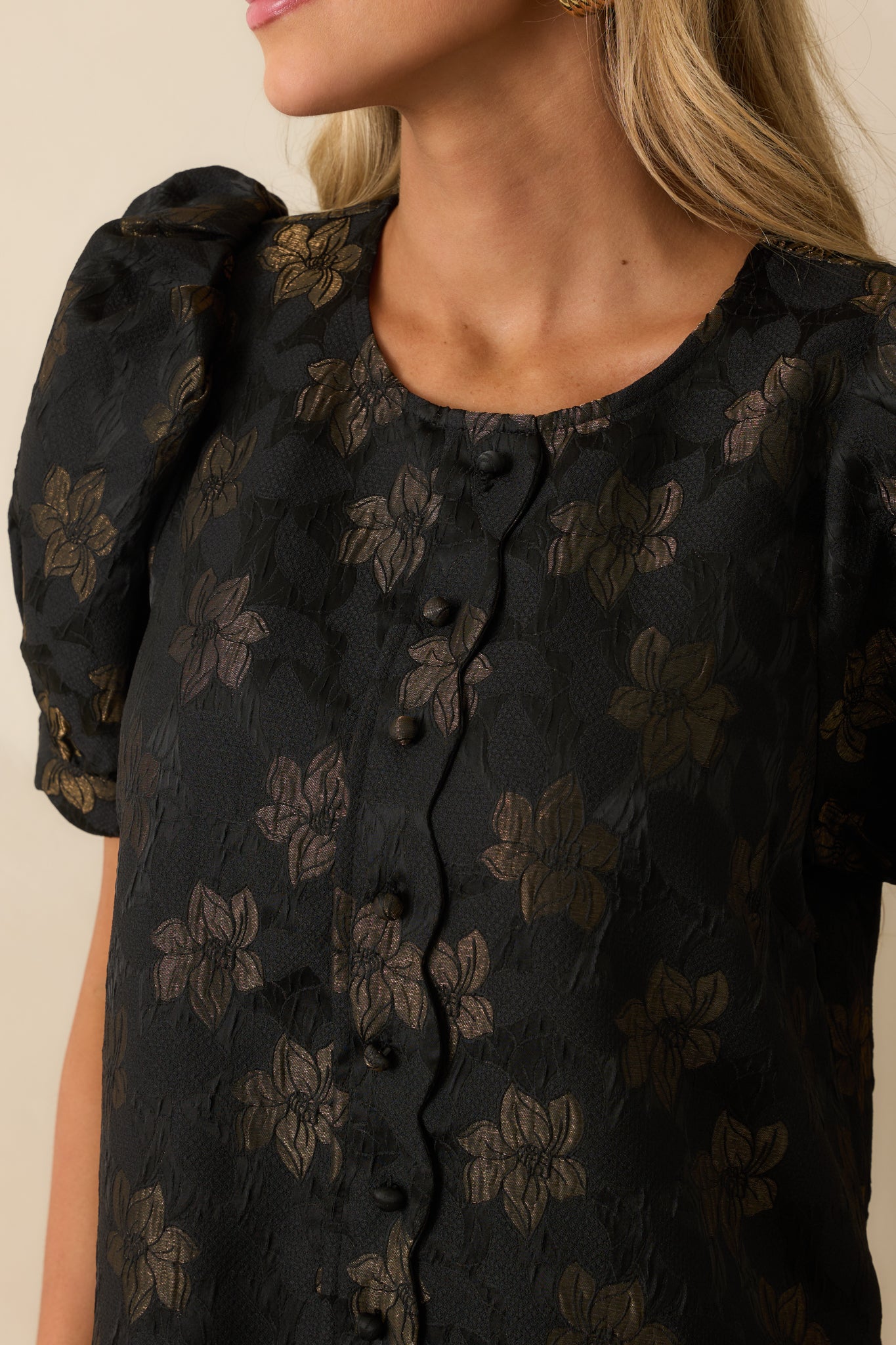 Detailed view of the floral jacquard fabric and scalloped trim on the dress.