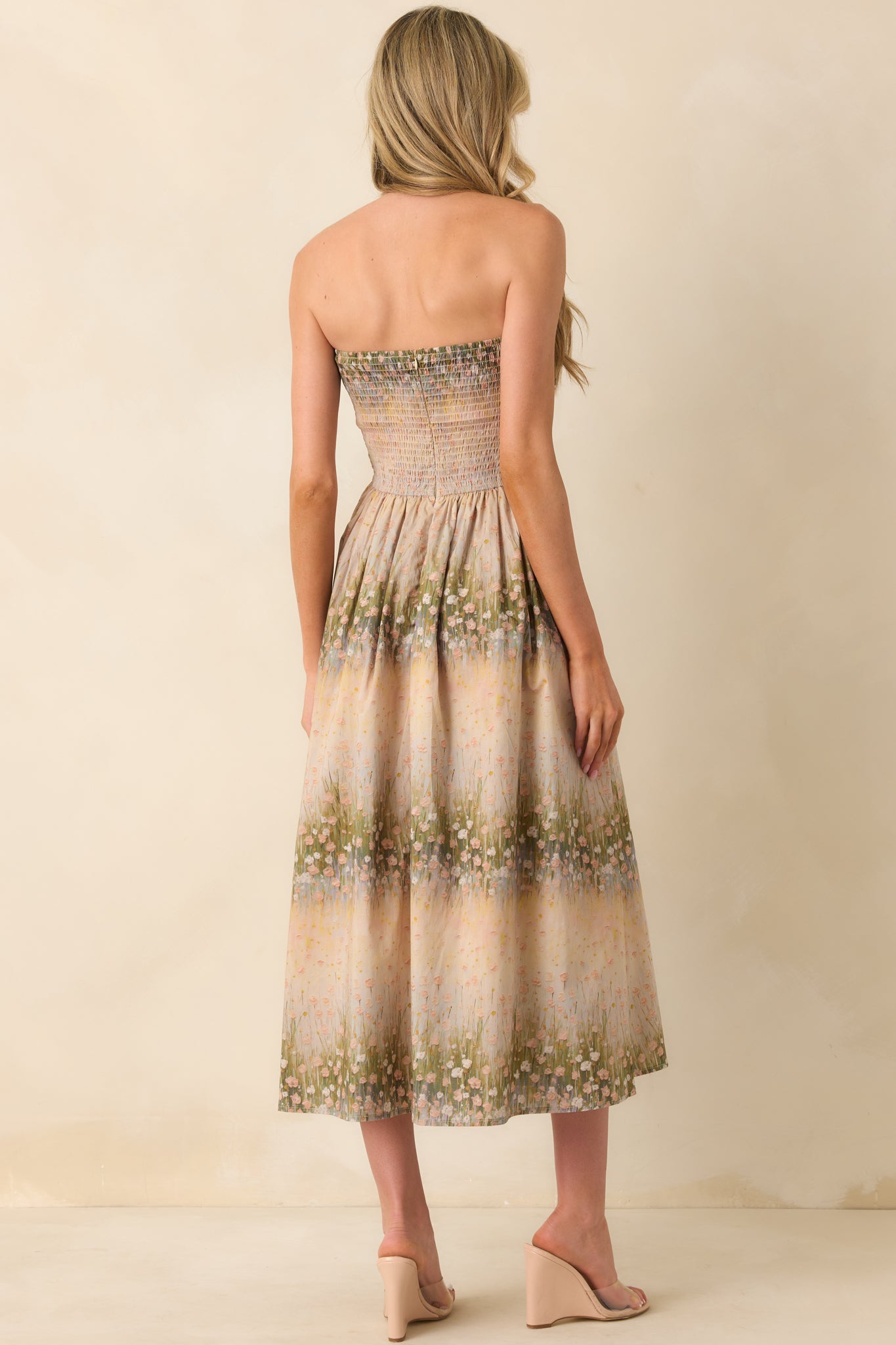 A back view of the dress highlighting the smocked panel and discrete back zipper.