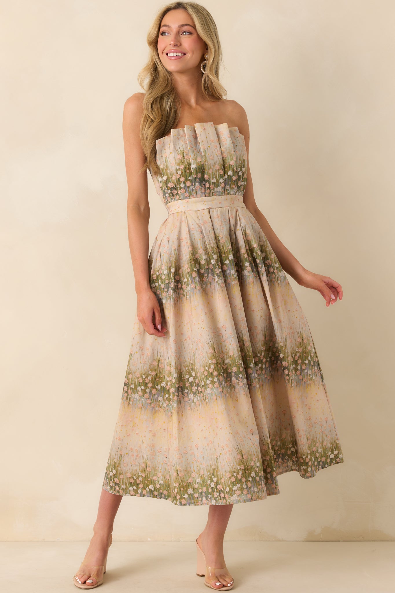 A full body photo capturing the relaxed drape and summery style of the floral strapless dress.