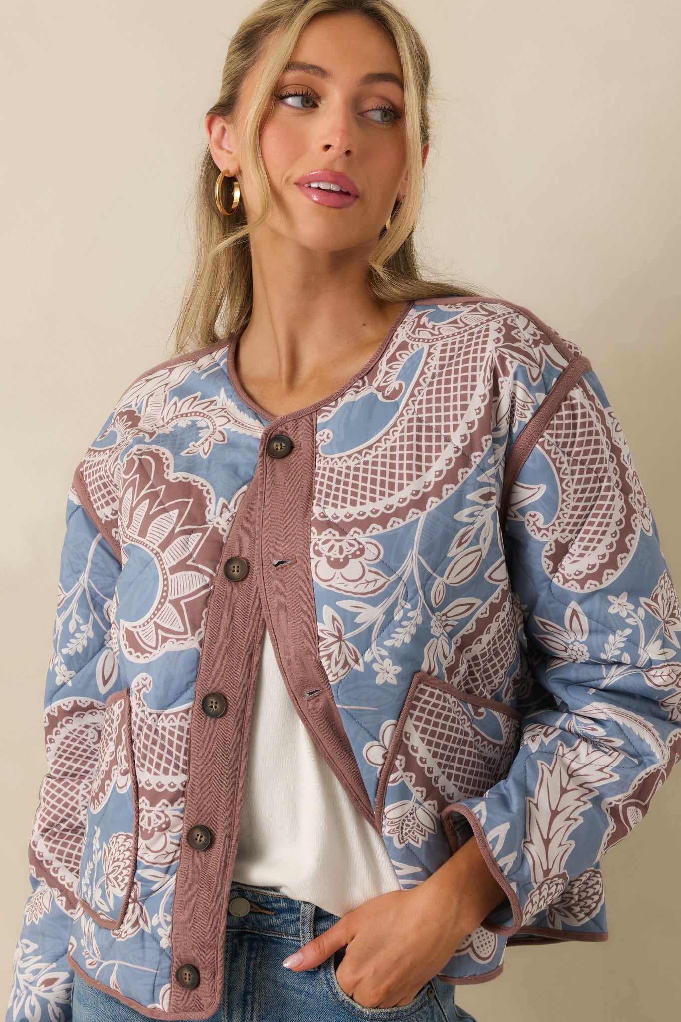 Focused view of the sleeve and trim, emphasizing the quilting detail and dusty blue with mauve floral print.