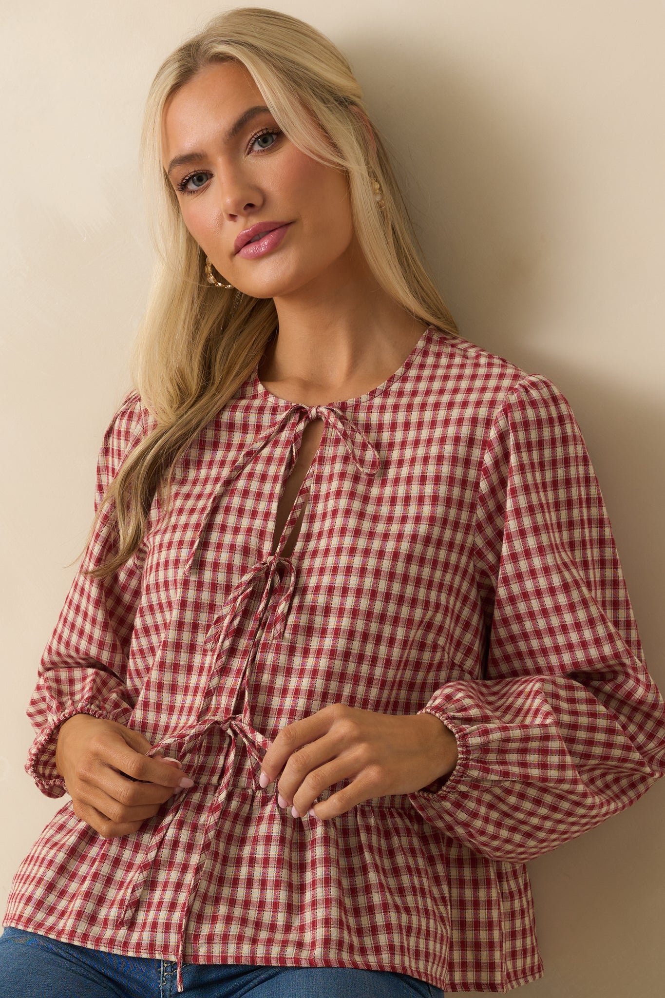 Detailed cropped view of gingham blouse showing relaxed peplum shape and checkered pattern.