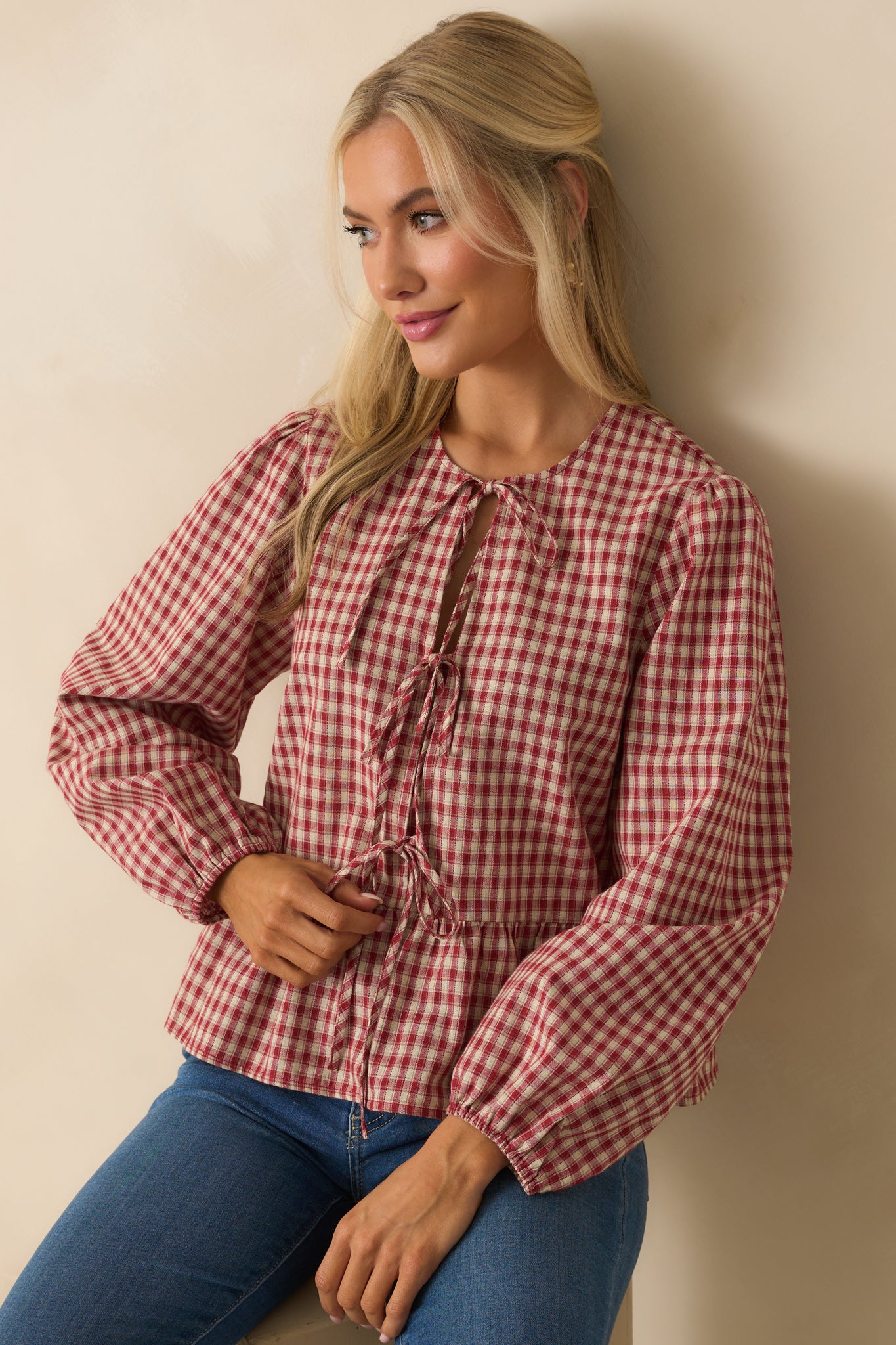 Cropped close front of gingham peplum top focusing on elastic cuffed balloon sleeves.